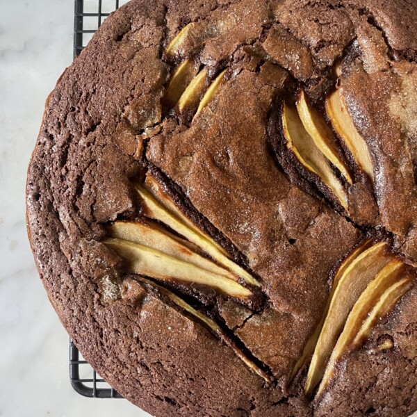 close up of chocolate and pear cake on wire rack