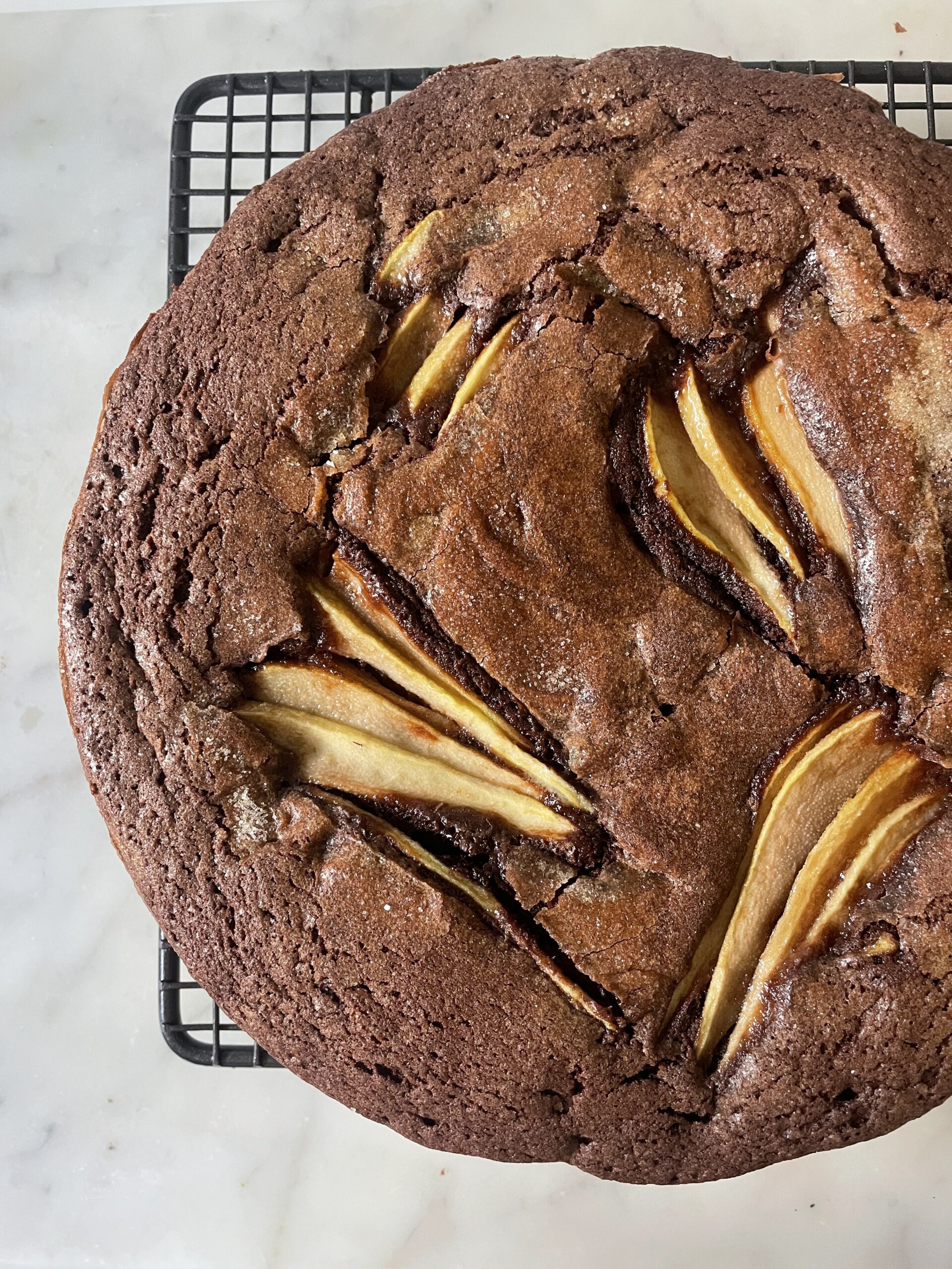 close up of chocolate and pear cake on wire rack