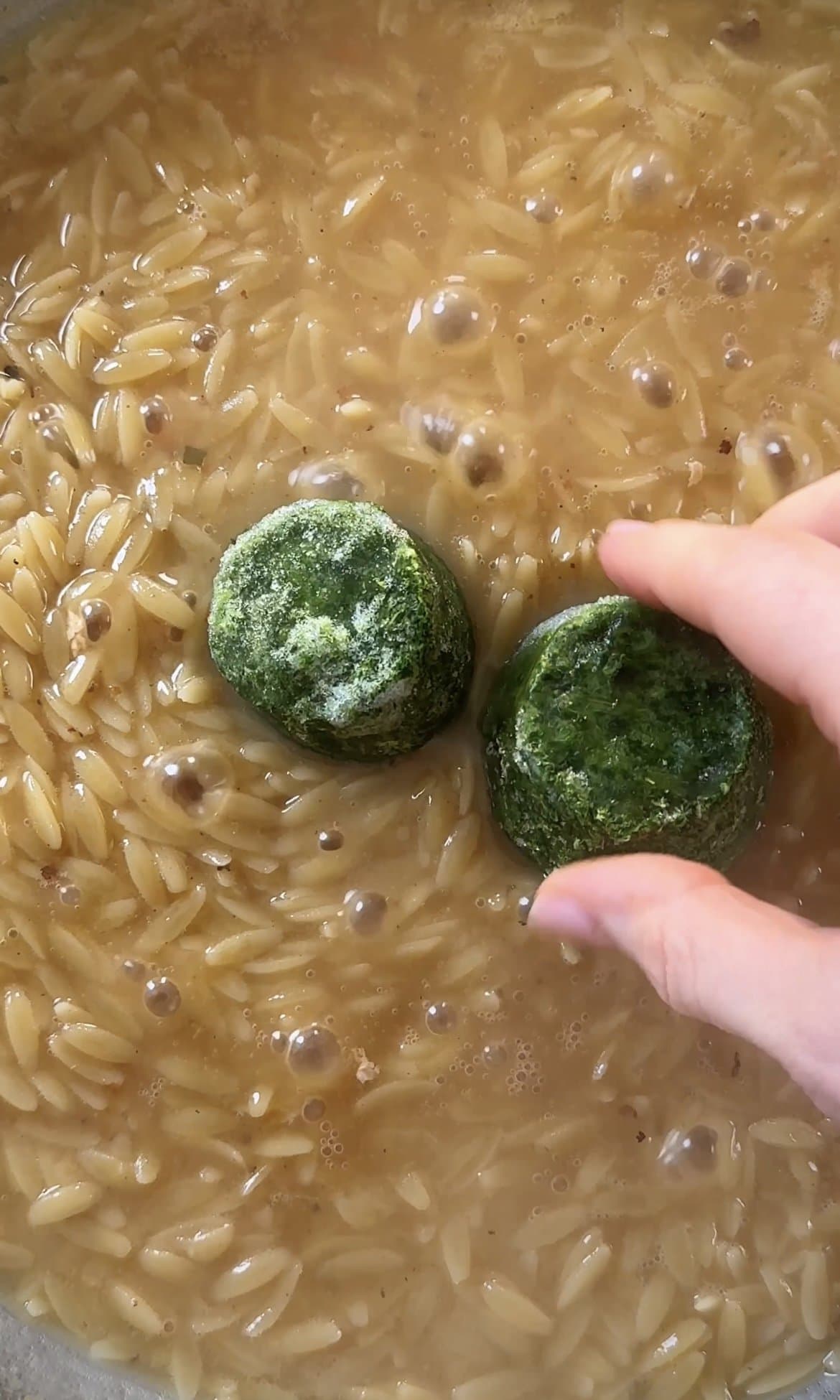 adding frozen spinach.