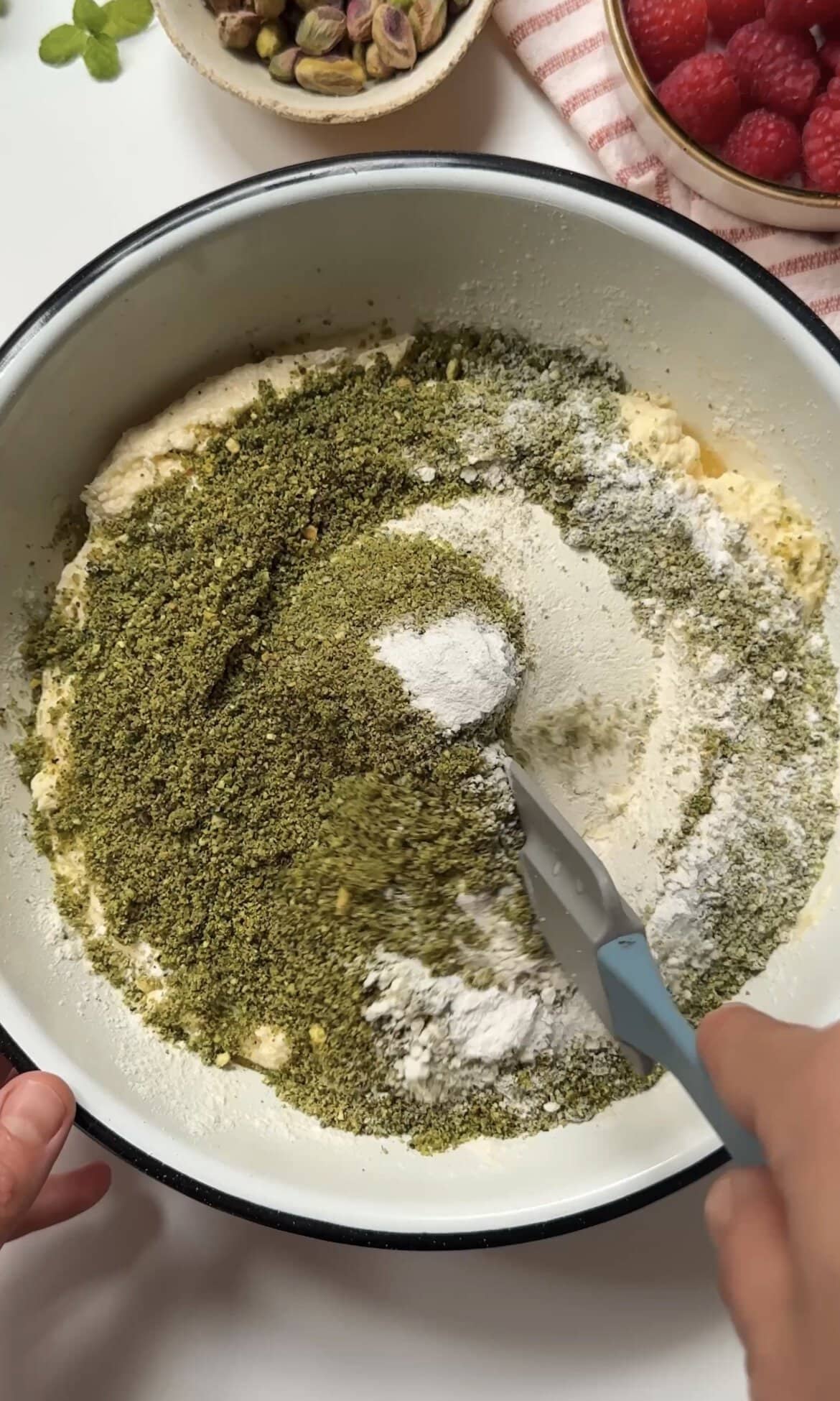 folding pistachios into the sponge batter.