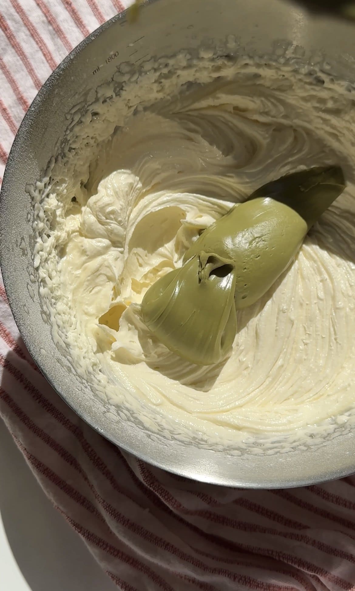 adding pistachio cream to the icing.