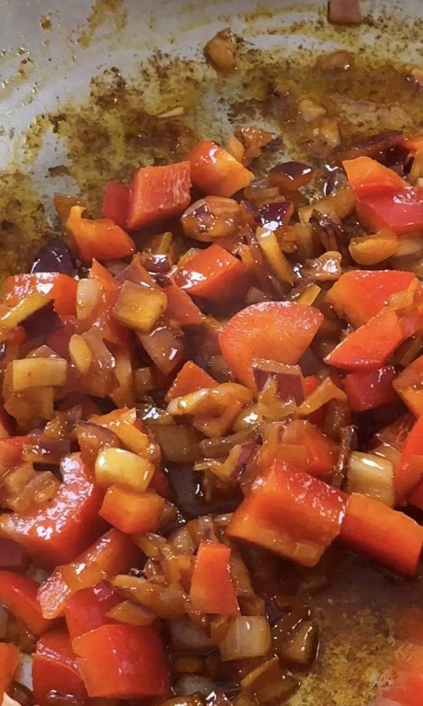 adding in red pepper to the frying onion and garlic.