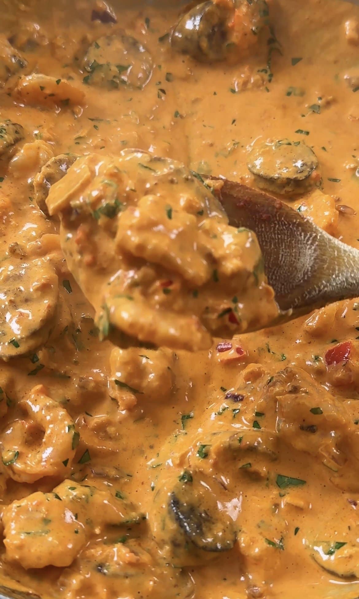 stirring prawn and chorizo creamy sauce together,