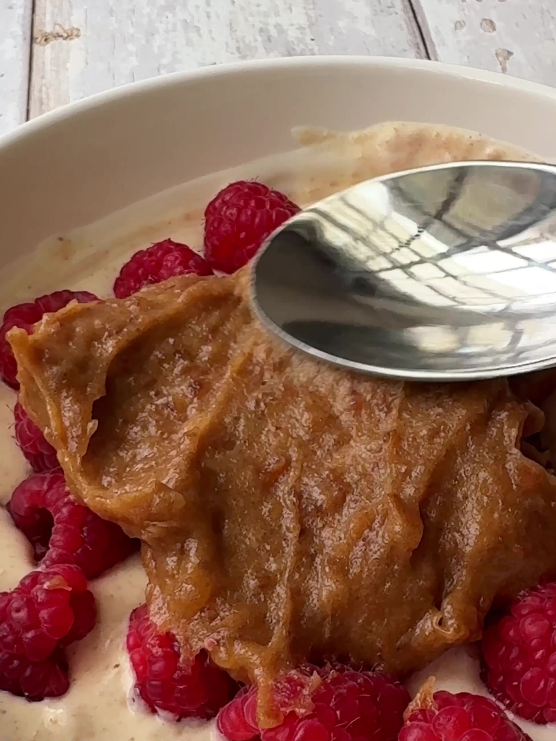 Spooning date caramel over raspberries