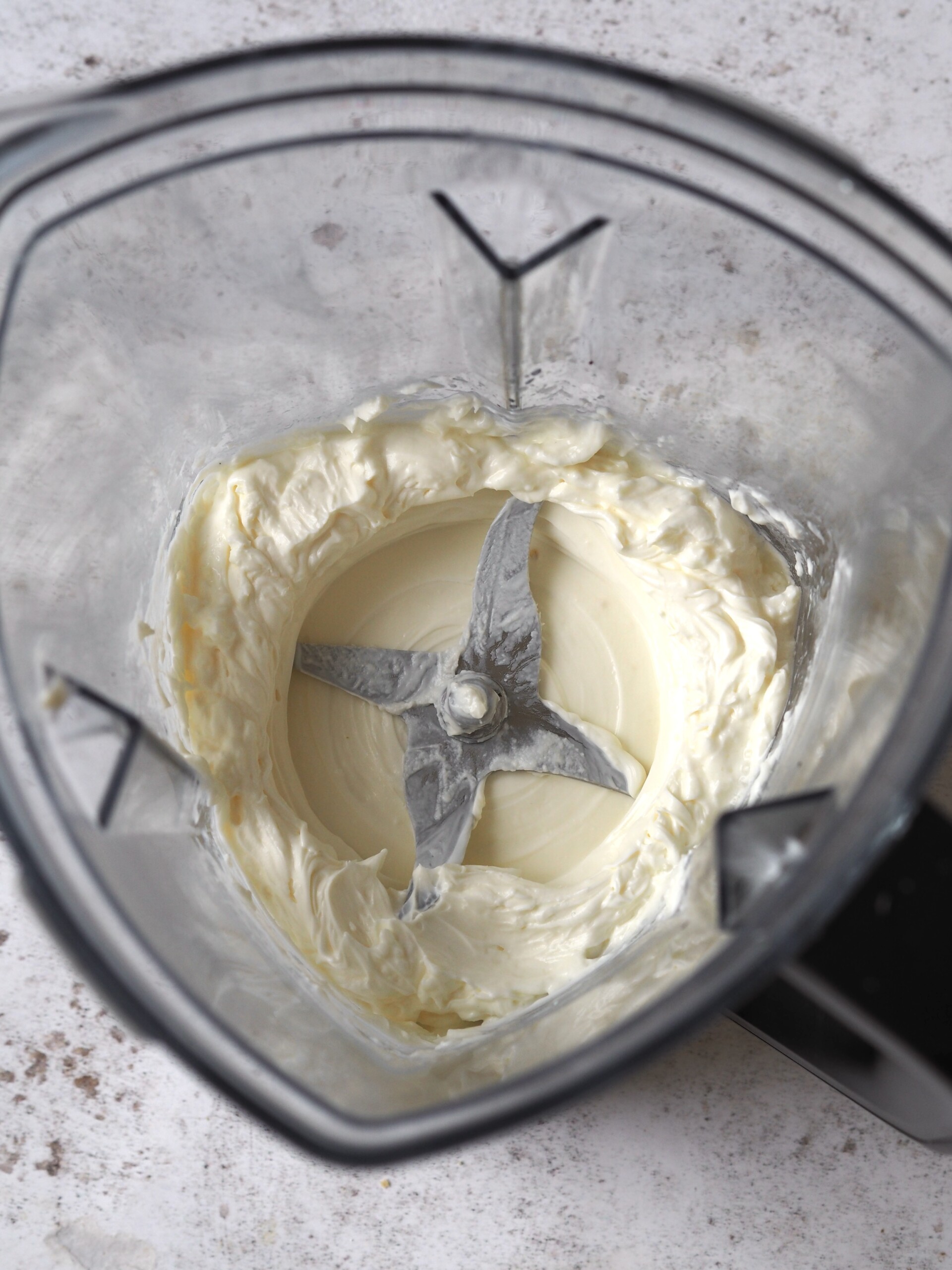 Cream cheese and lemon juice blitzed in the bottom of a blender.