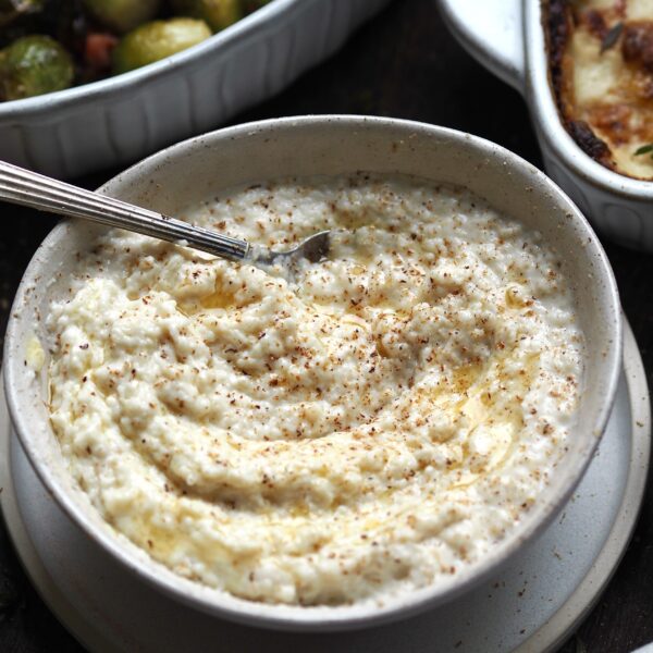 Bowl of bread sauce with dishes of bacon sprouts and cheesy leeks in the background.