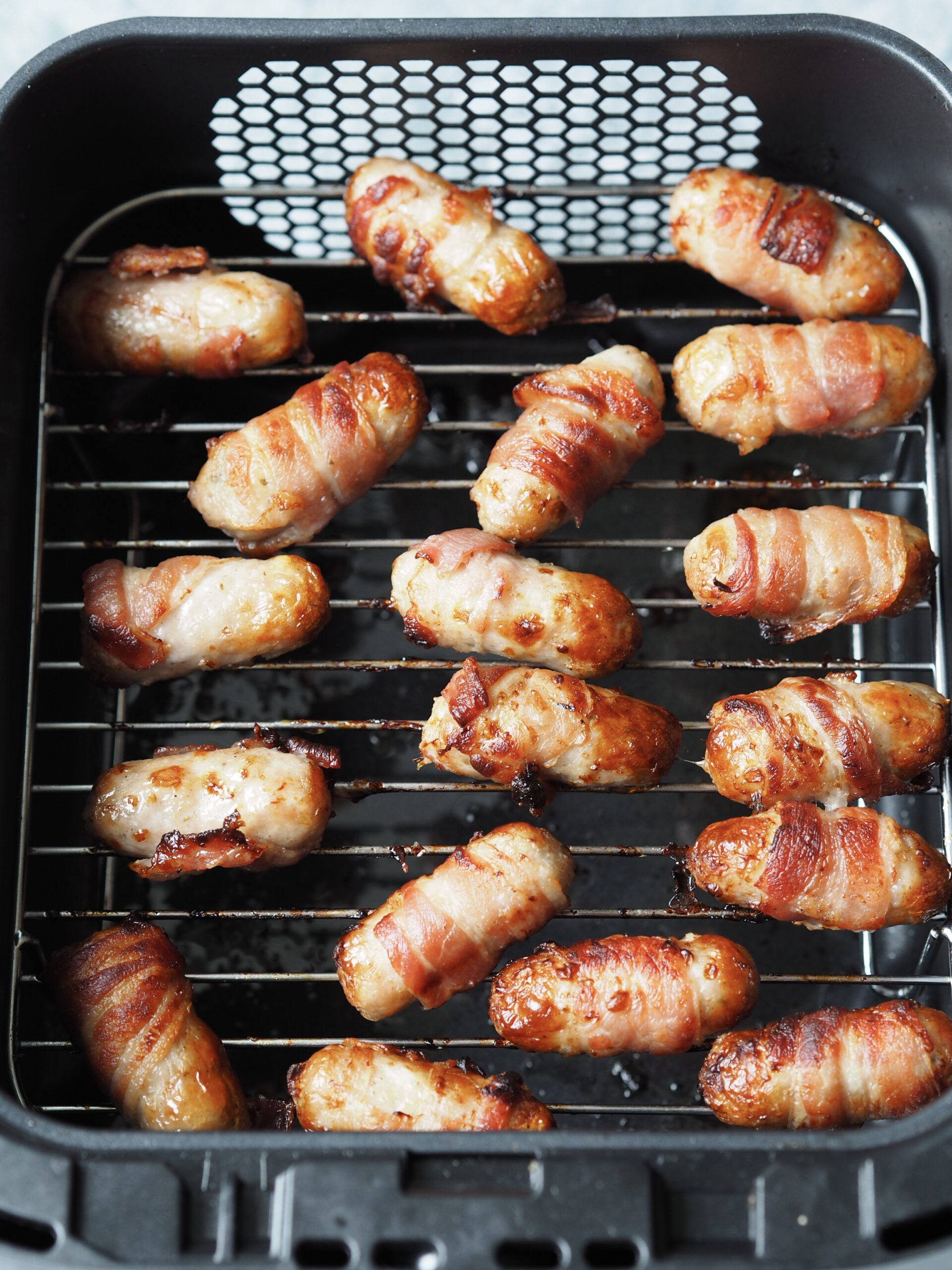 Close up of cooked pigs in blankets in the air fryer.