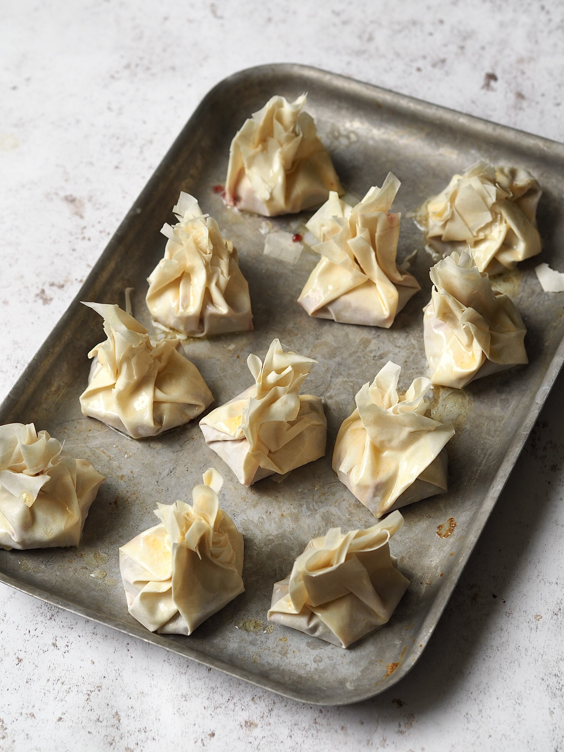 Cranberry brie filo bites on a metal baking tray.