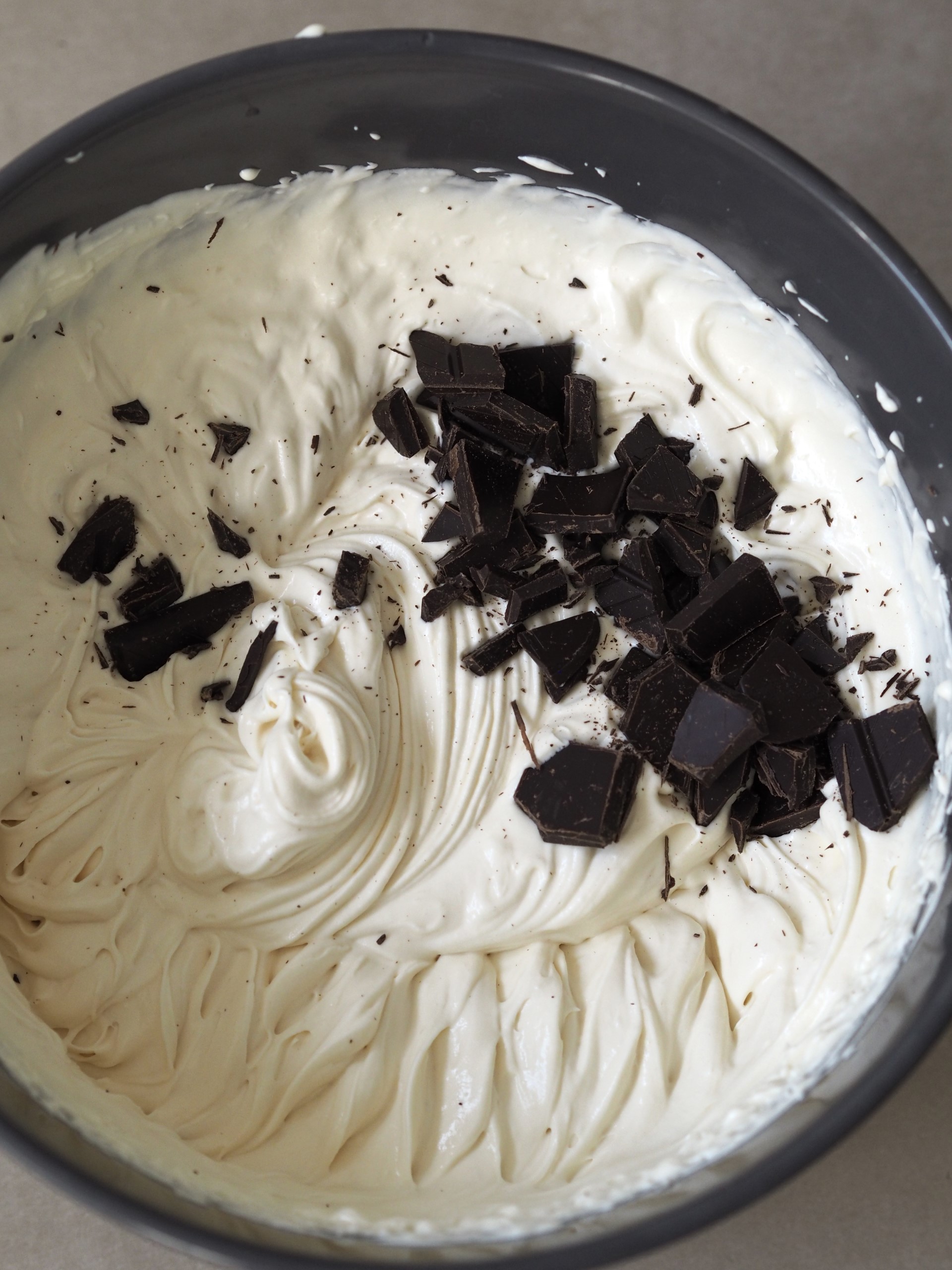 Adding dark chocolate chunks to the ice cream mixture.