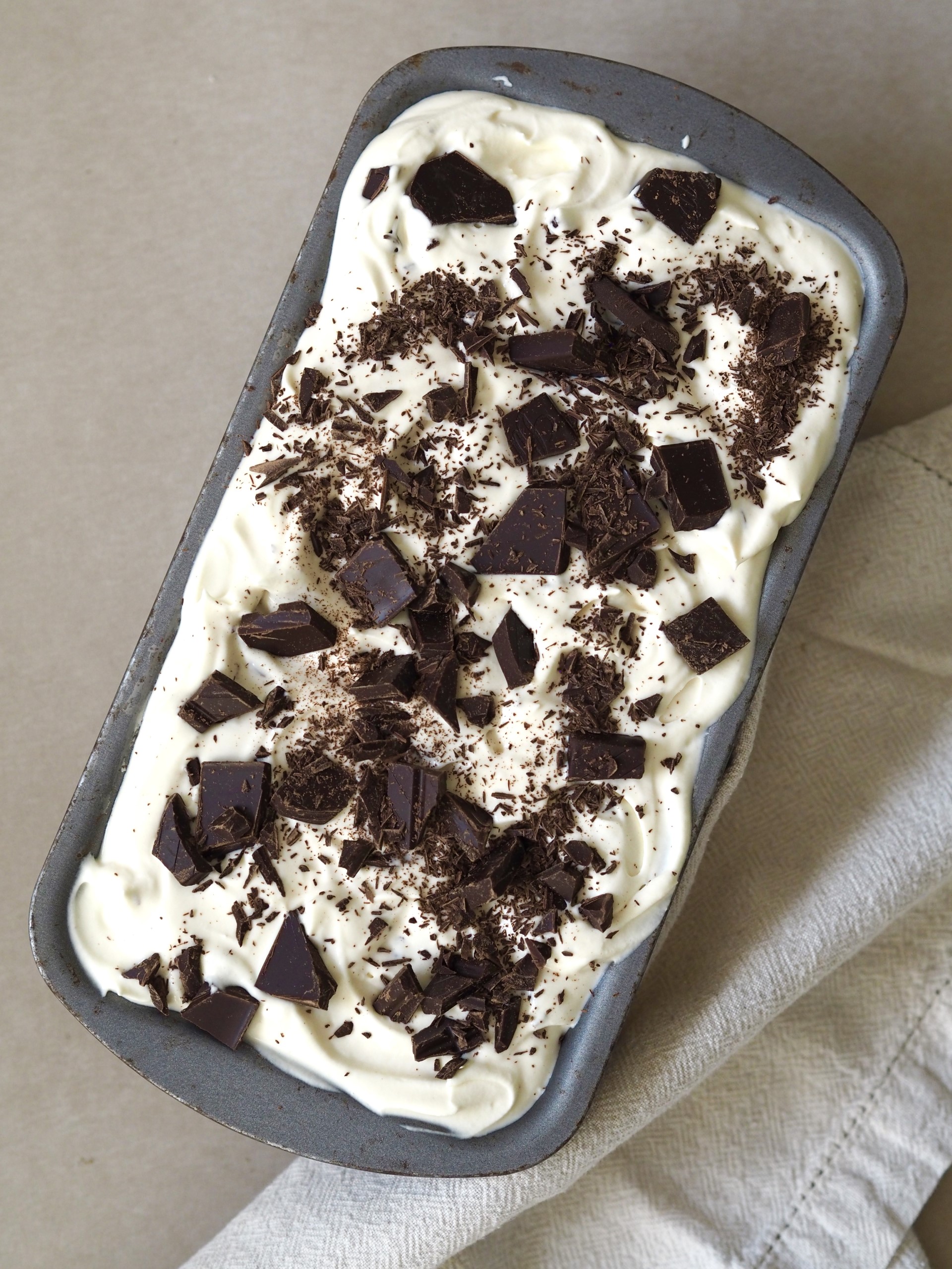 Sprinkling chopped chocolate on top of the ice cream before chilling.