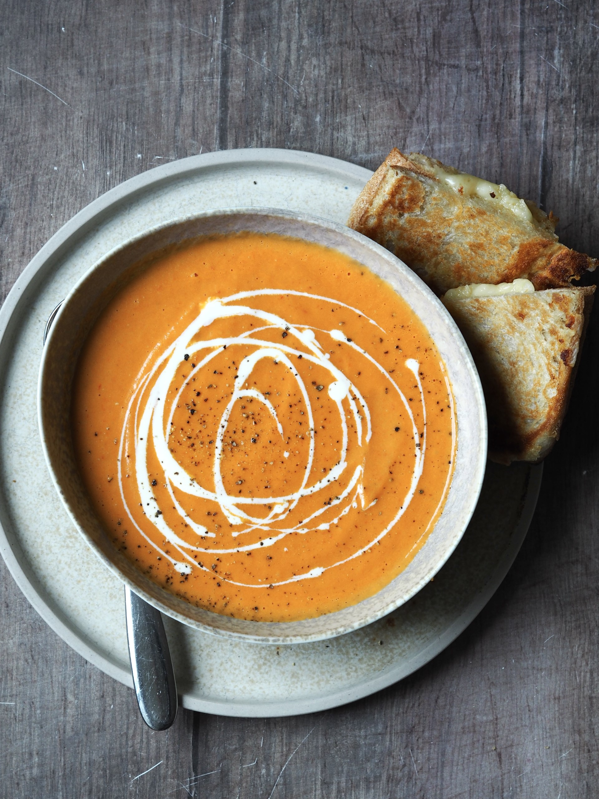 Serving tomato Soup with Grilled Cheese sandwich