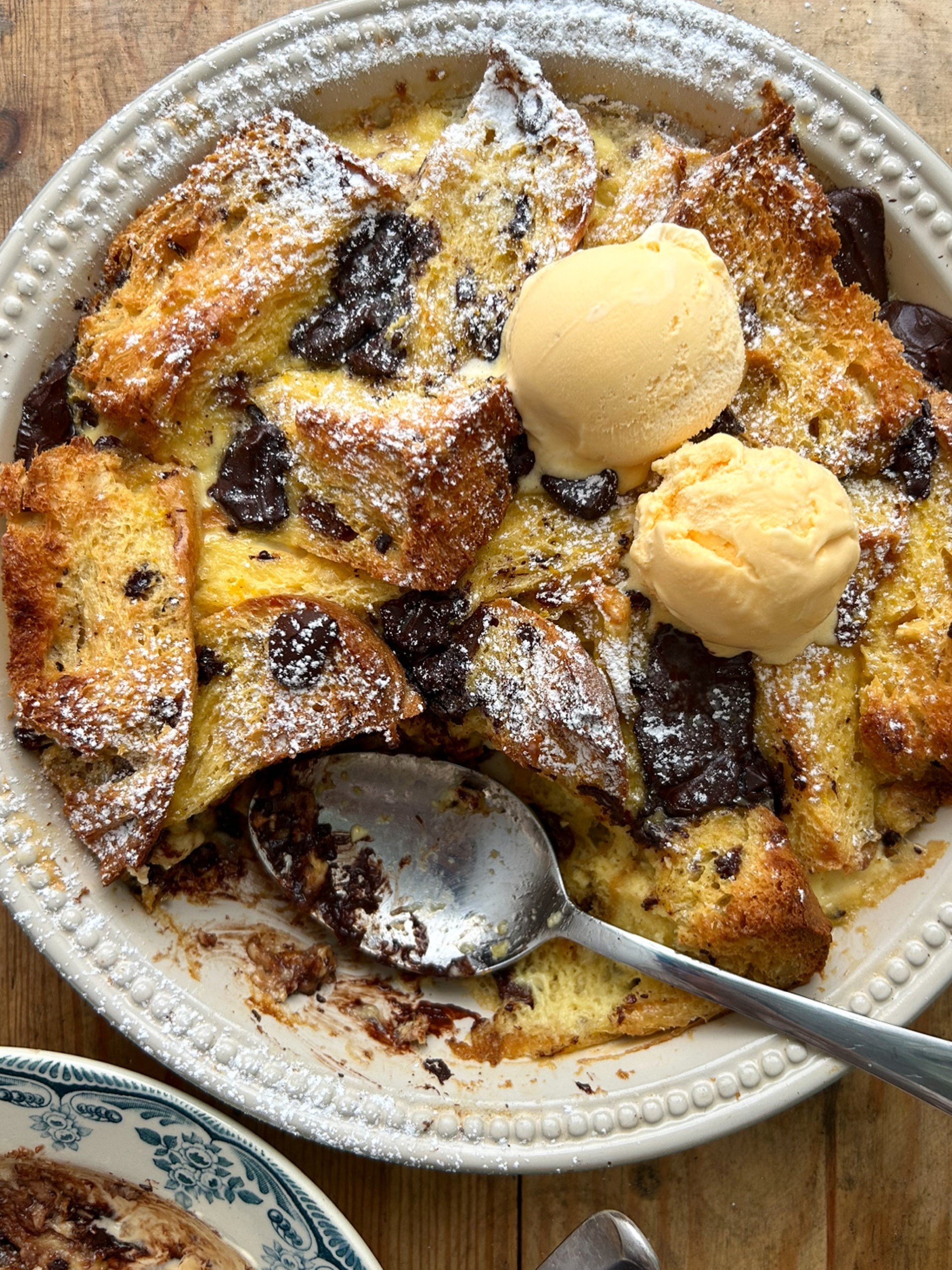 Dishing up Panettone, Orange and Dark Chocolate Bread and Butter Pudding in a bowl with ice cream