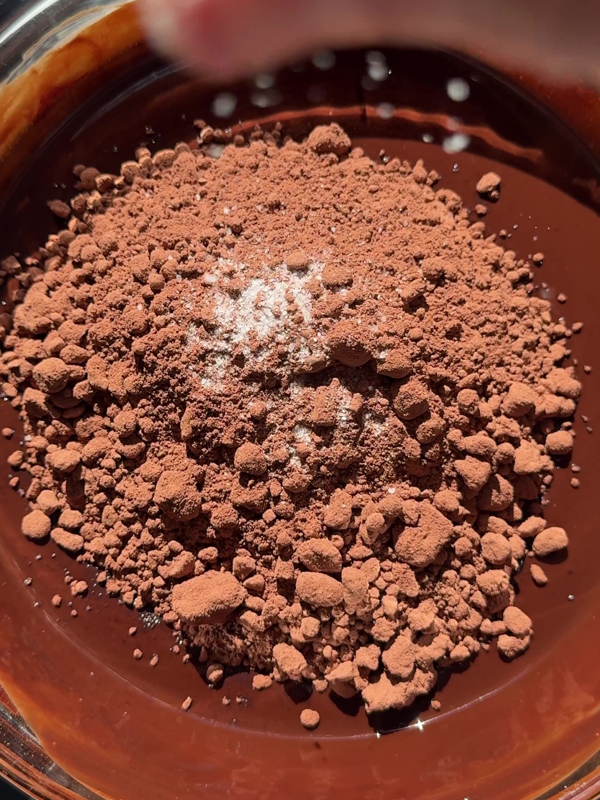 Adding cocoa and salt to melted chocolate