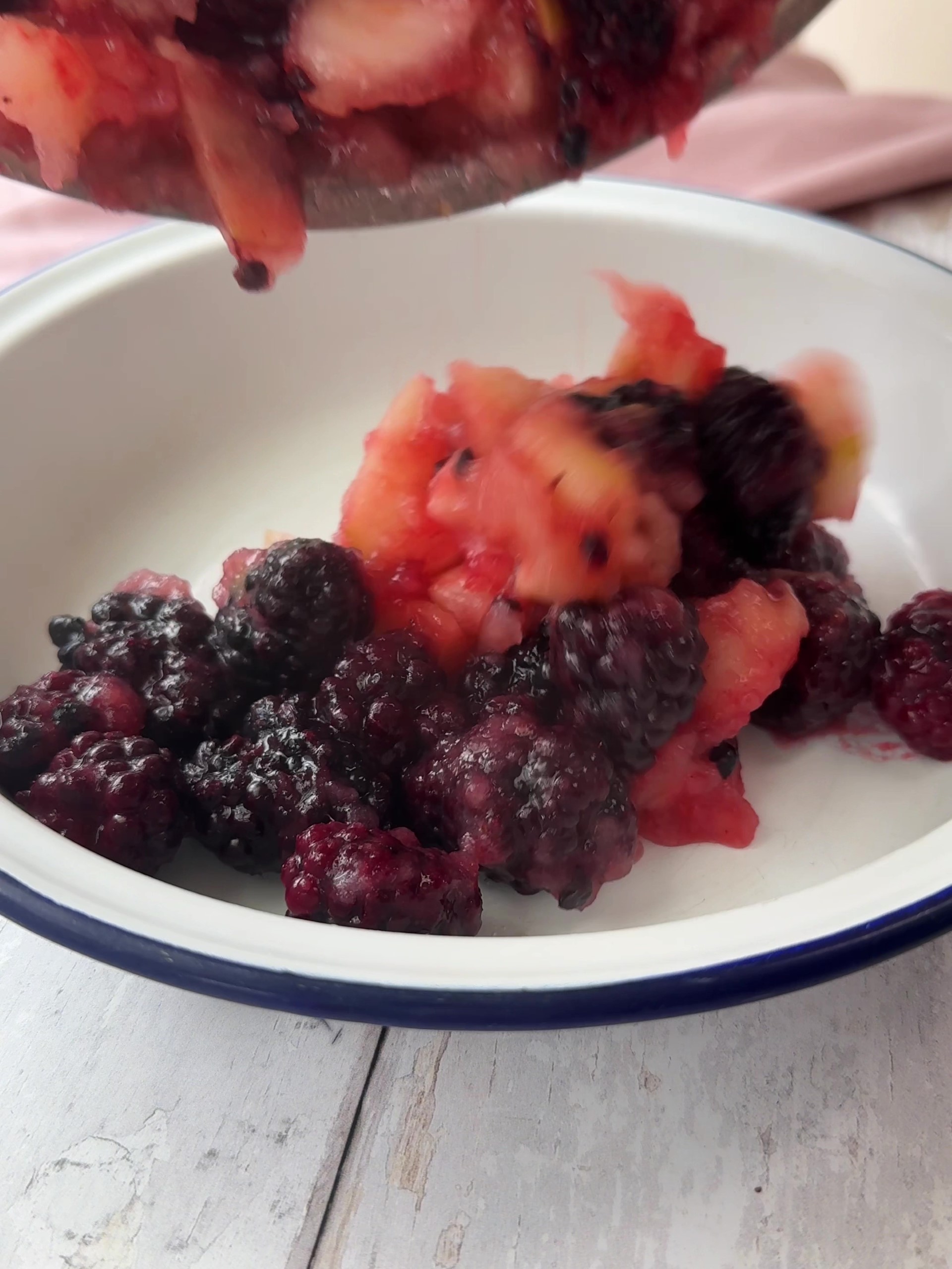 Spooning berries and apples into dish