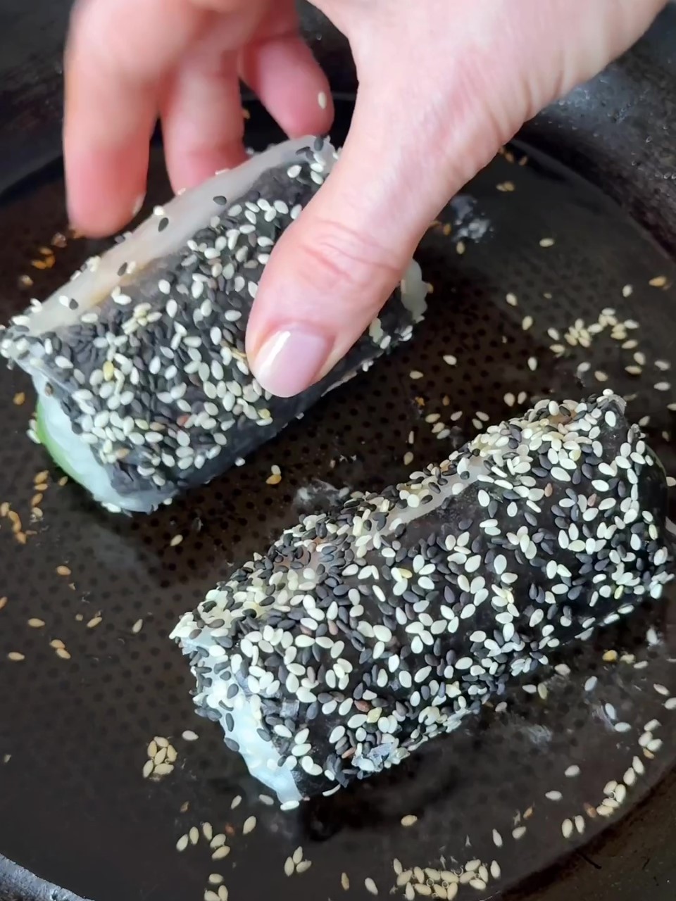 Rolling rolls in sesame seeds