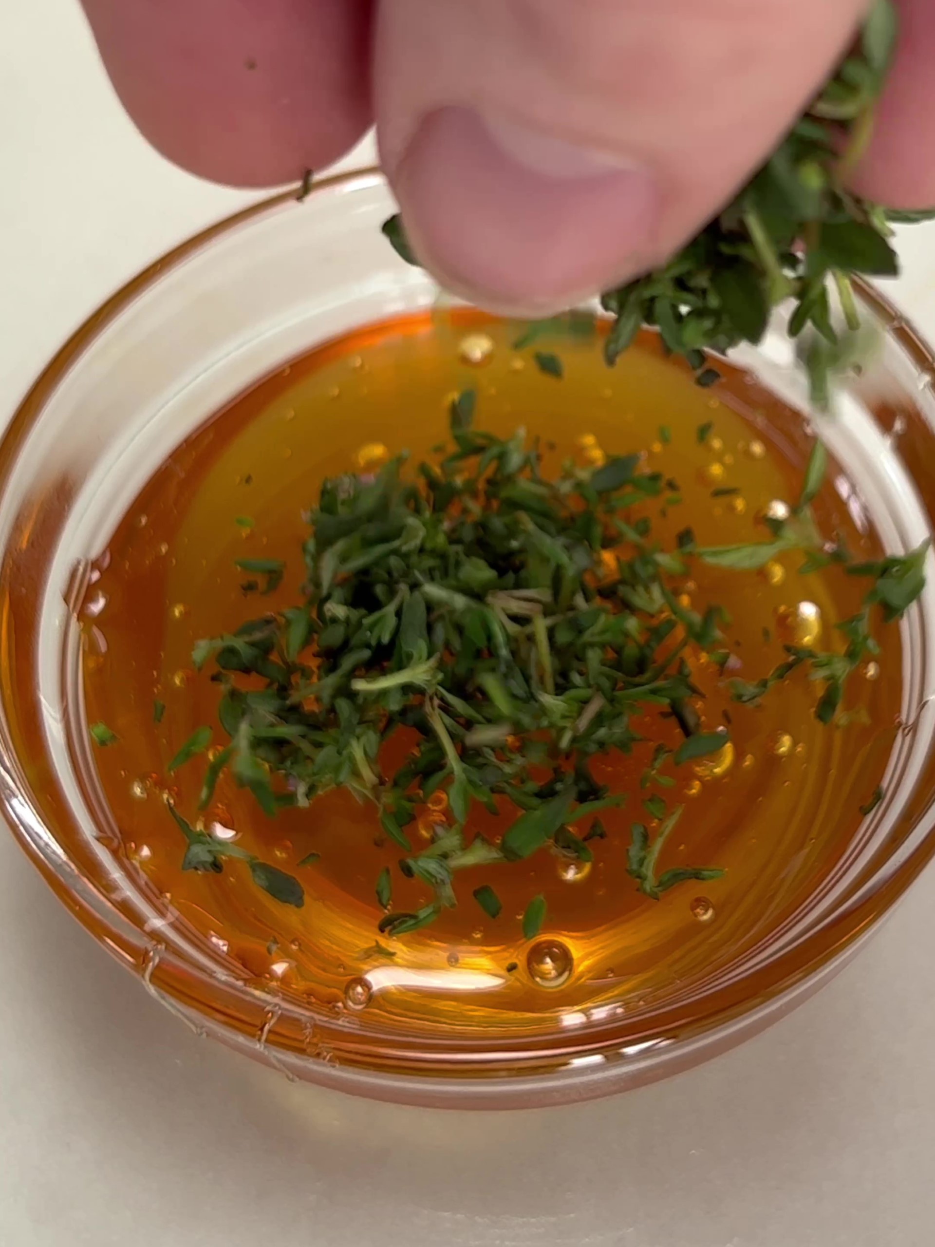 Adding thyme leaves to honey