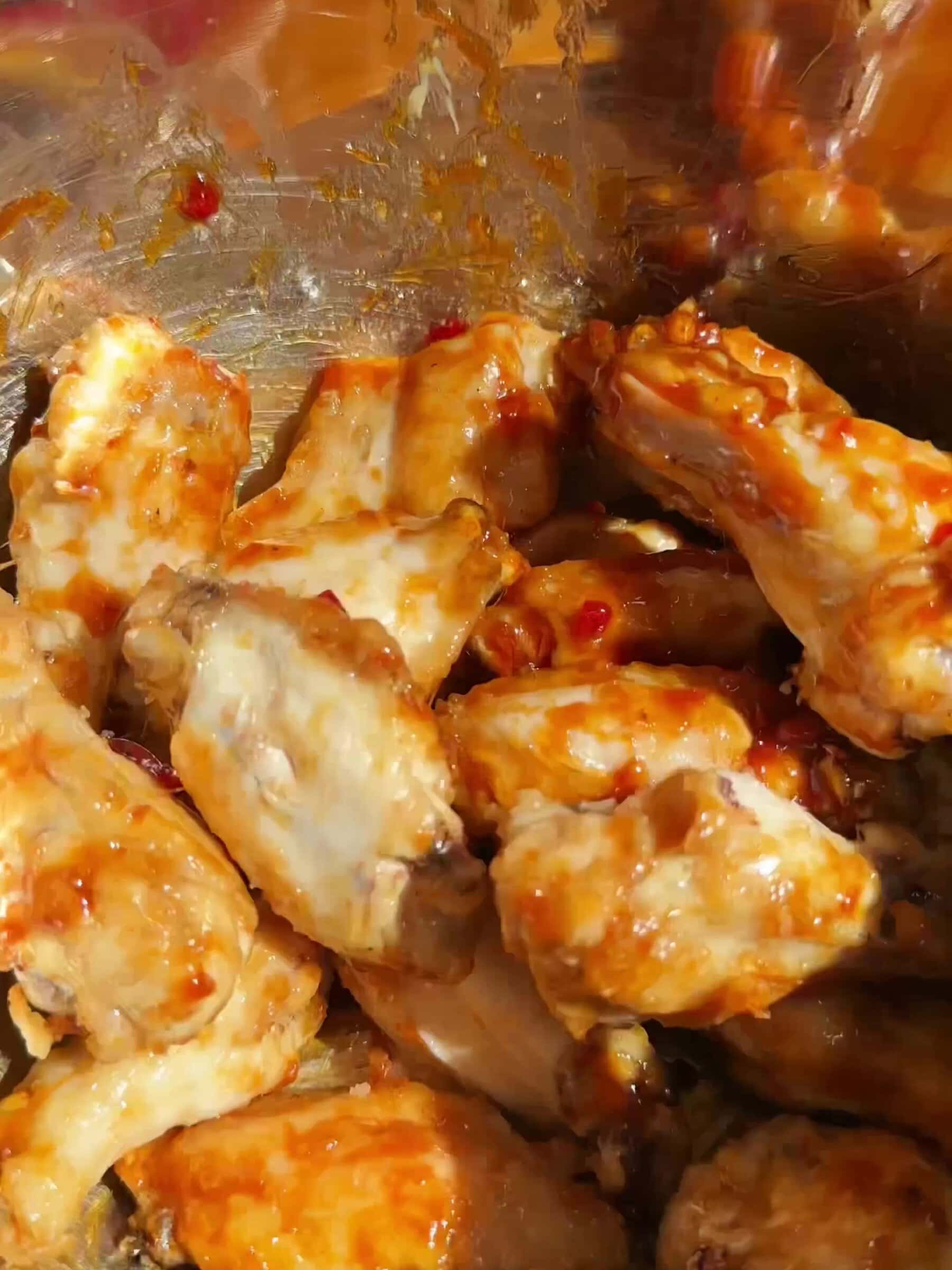 Mixing Chicken wings with hot honey sauce