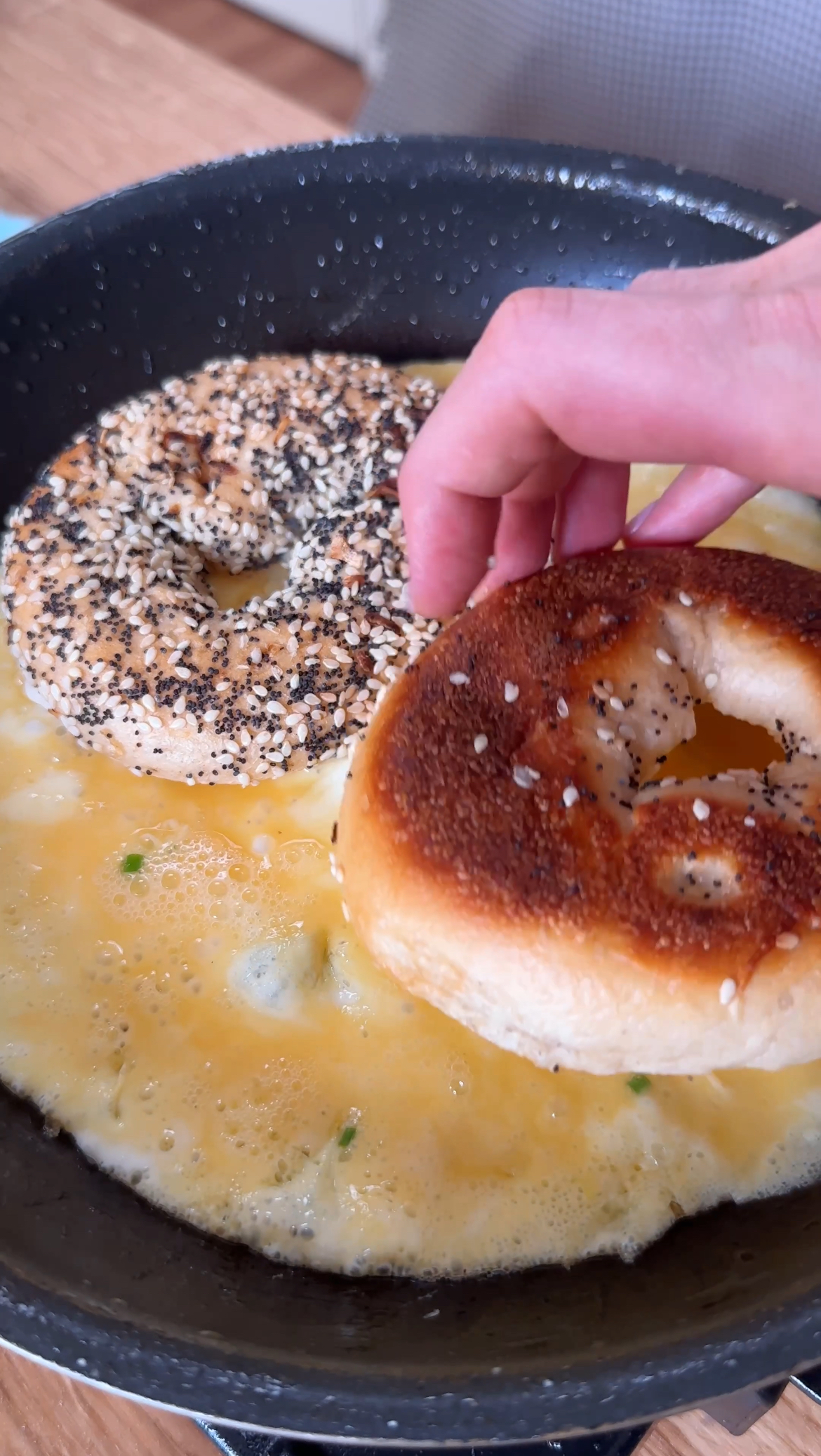 adding bagel halves to the egg.