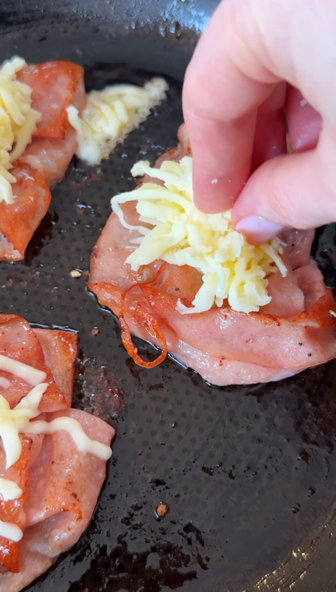 adding melted cheese to mortadella.