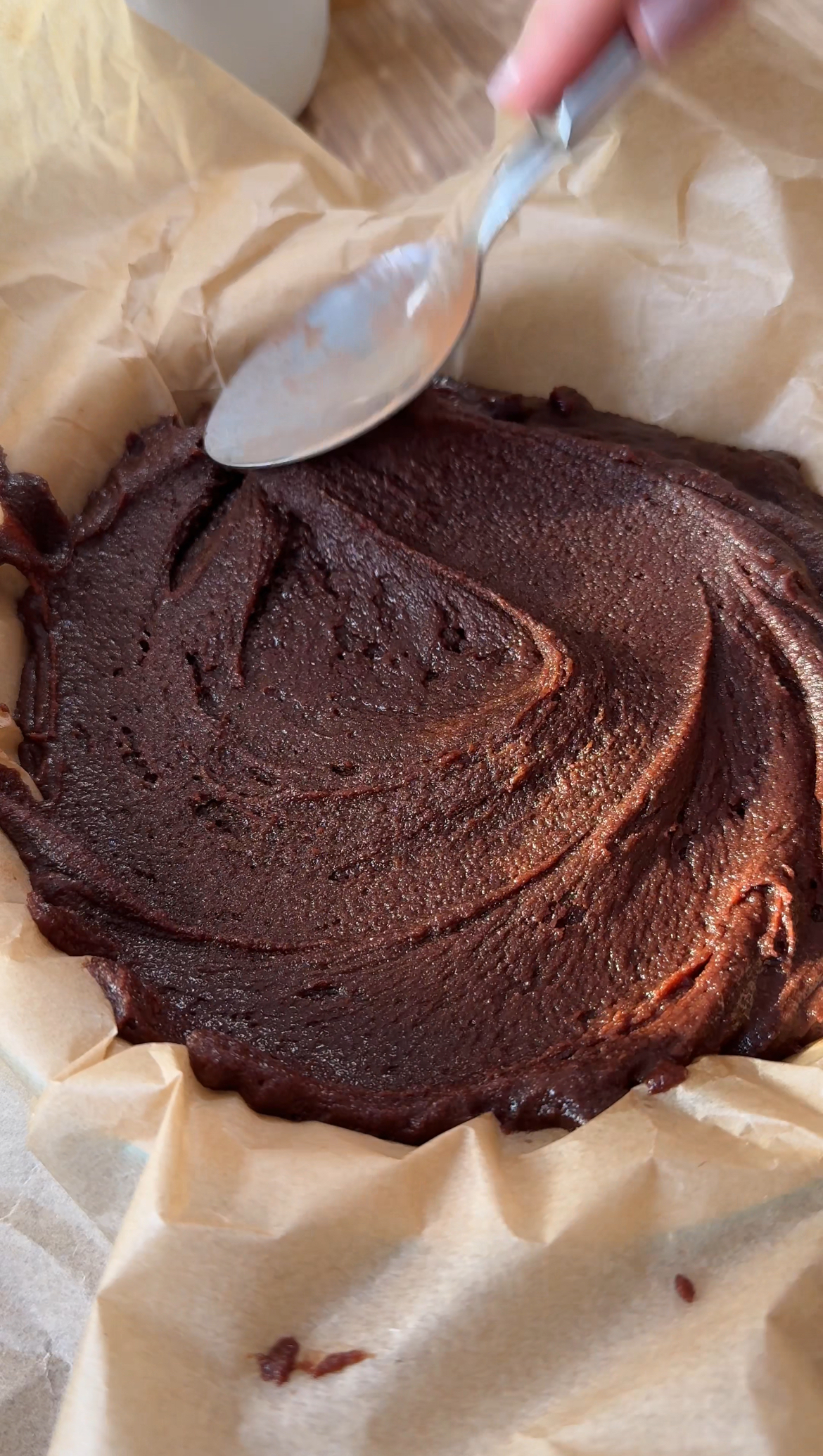 smoothing brownies into a tin.