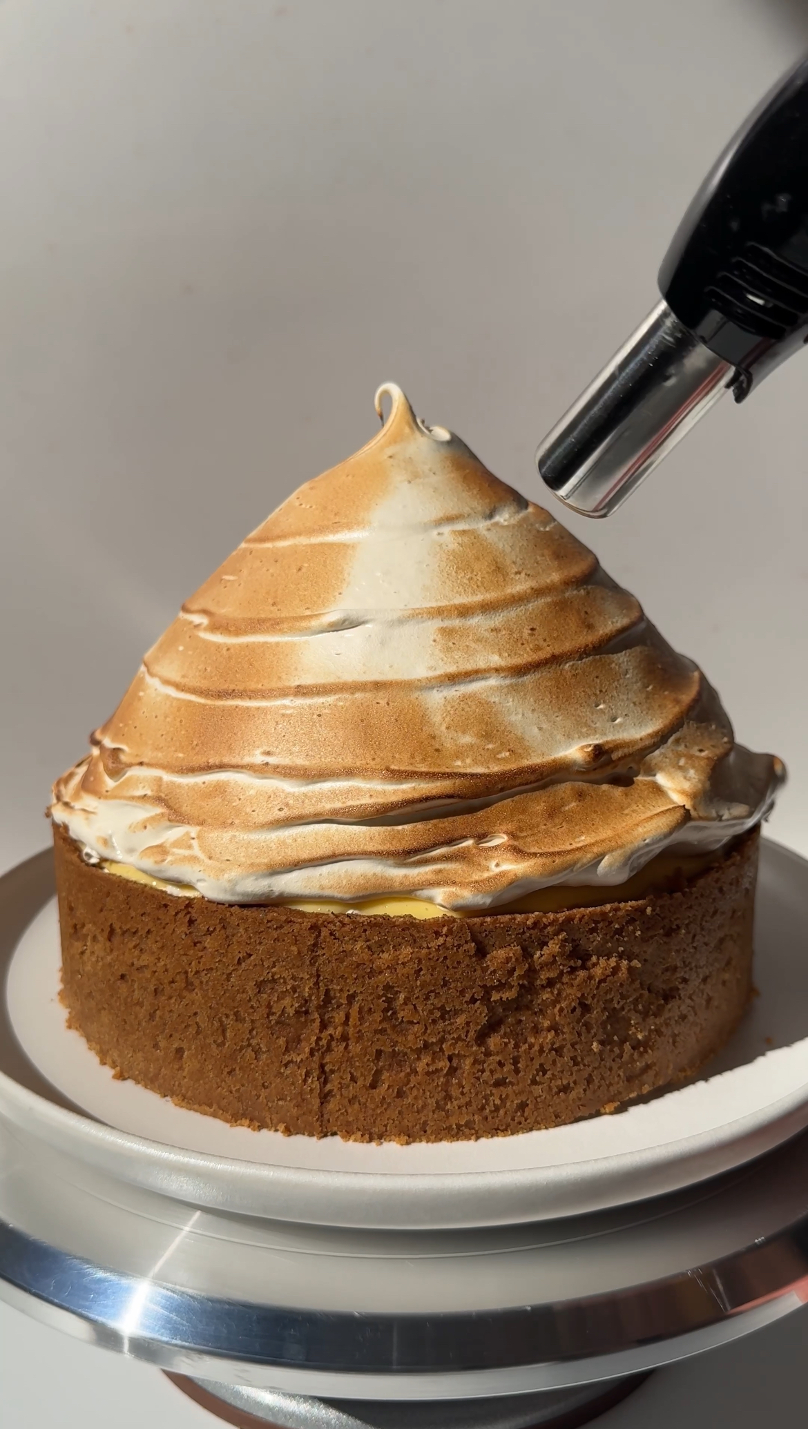 blowtorching lemon meringue cheesecake