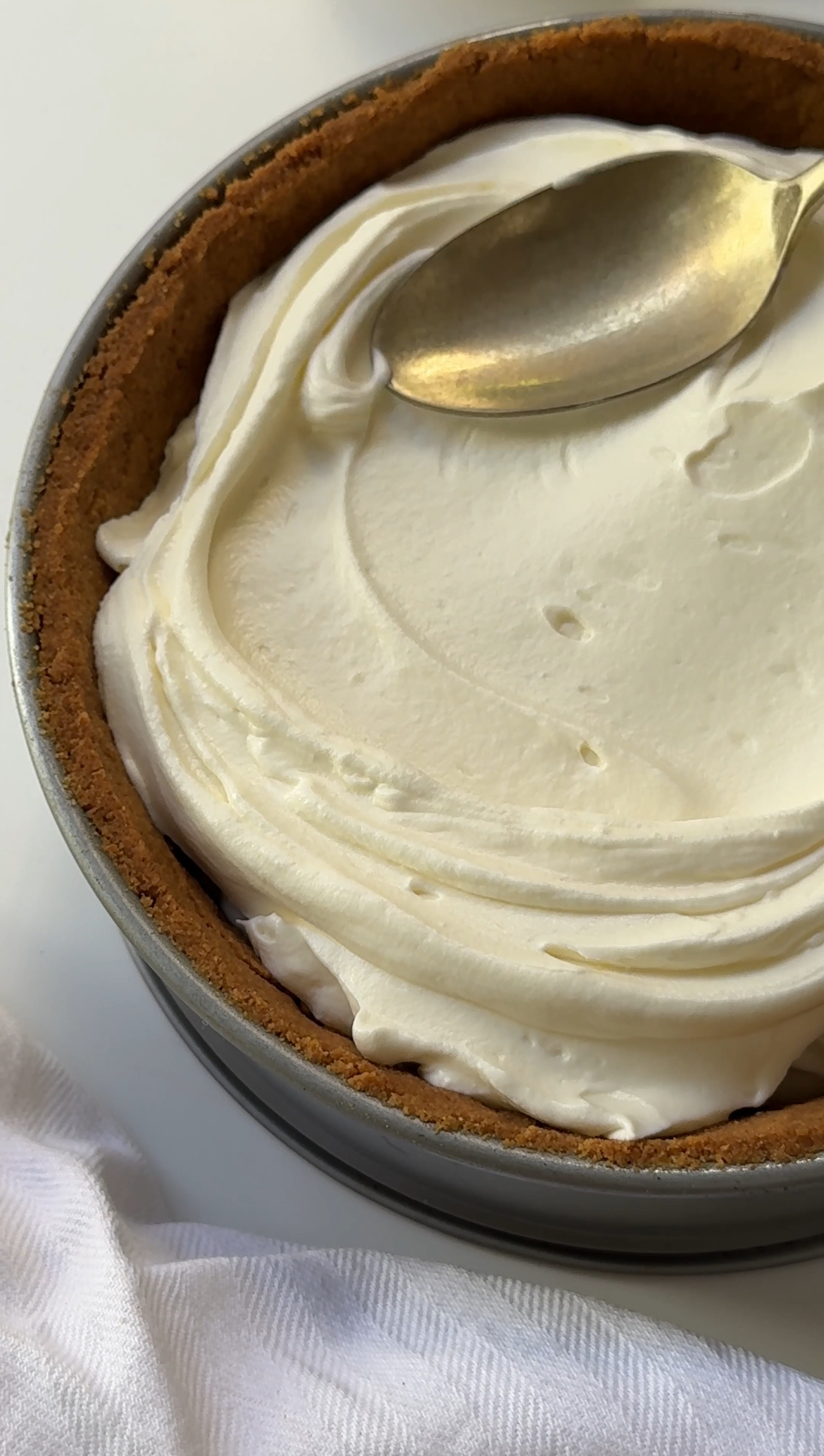 smoothing cheesecake filling on the base