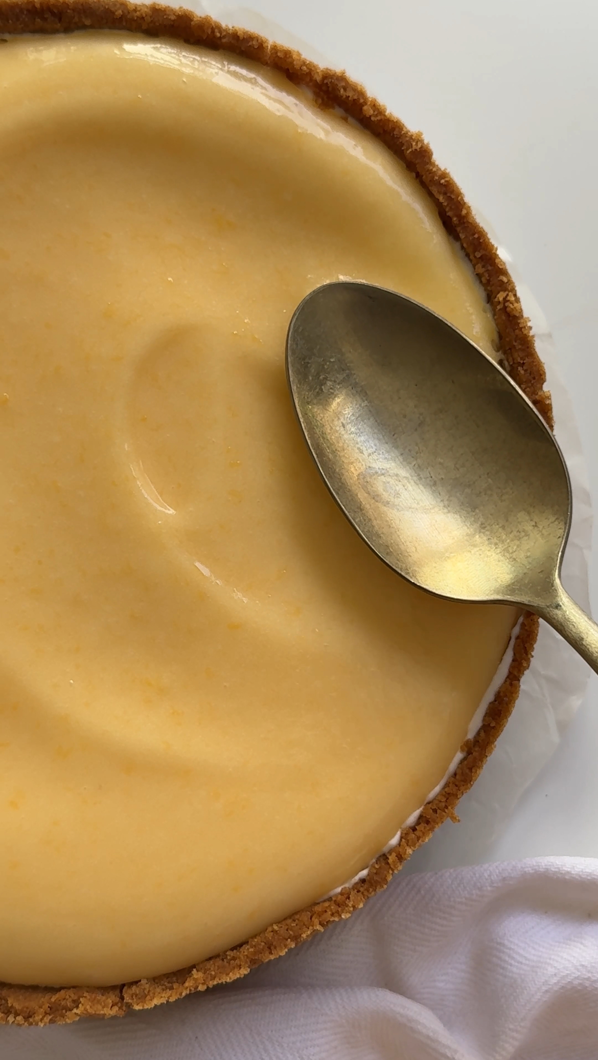 smoothing lemon curd onto cheesecake base