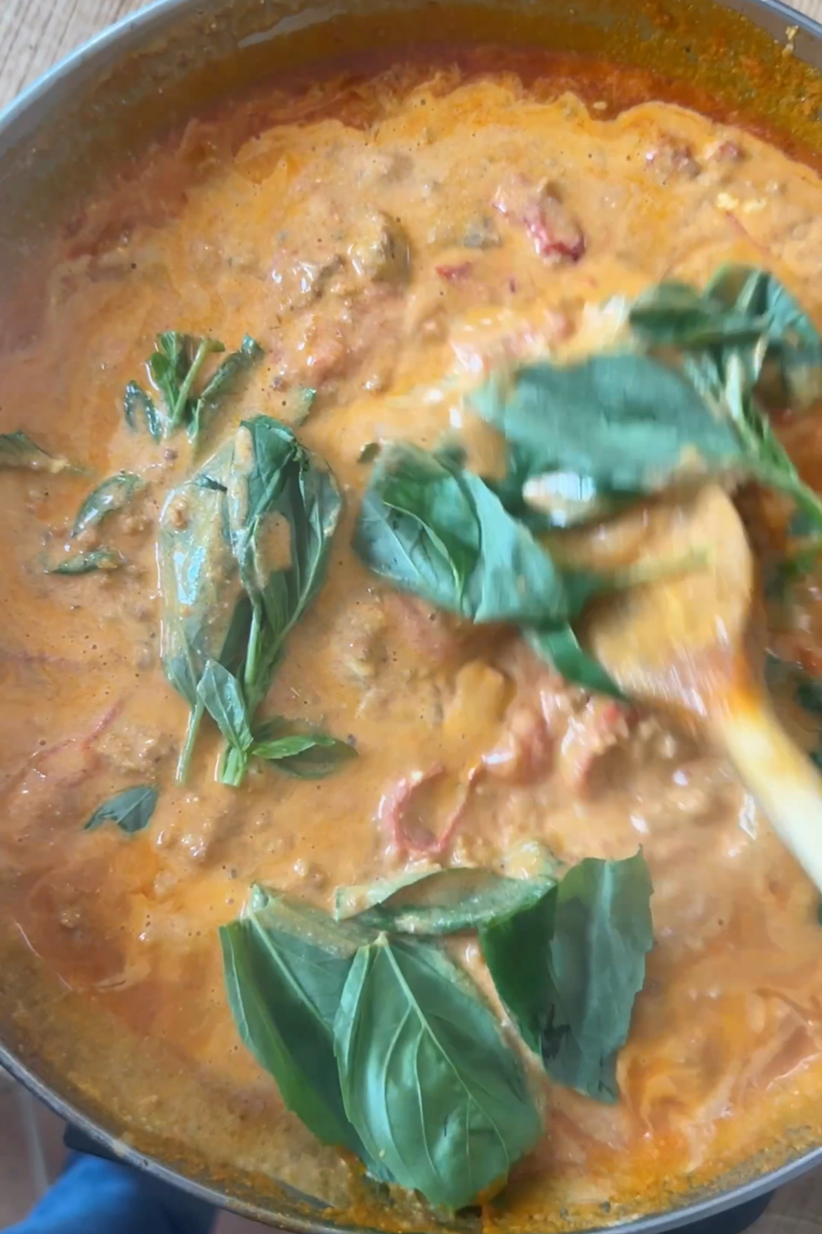 adding basil to the sauce