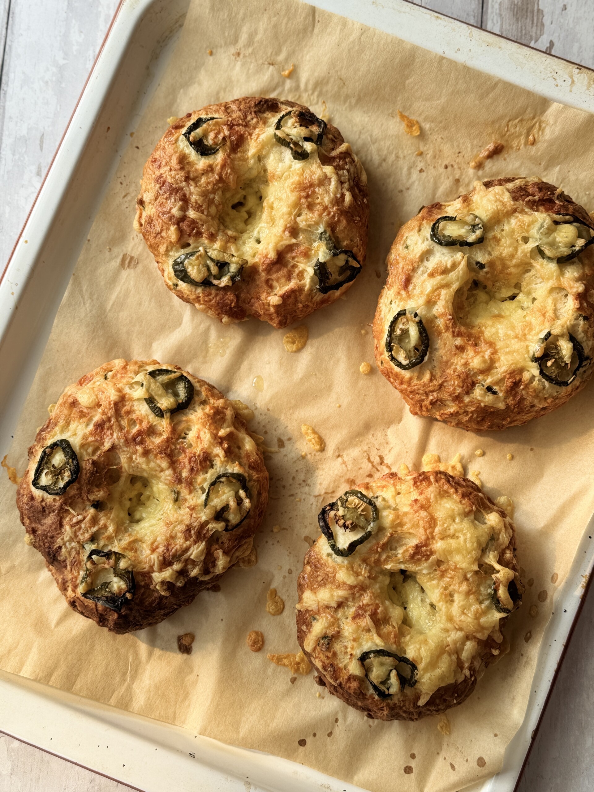 3 ingredient bagel with cheese and jalapeno on a tray.