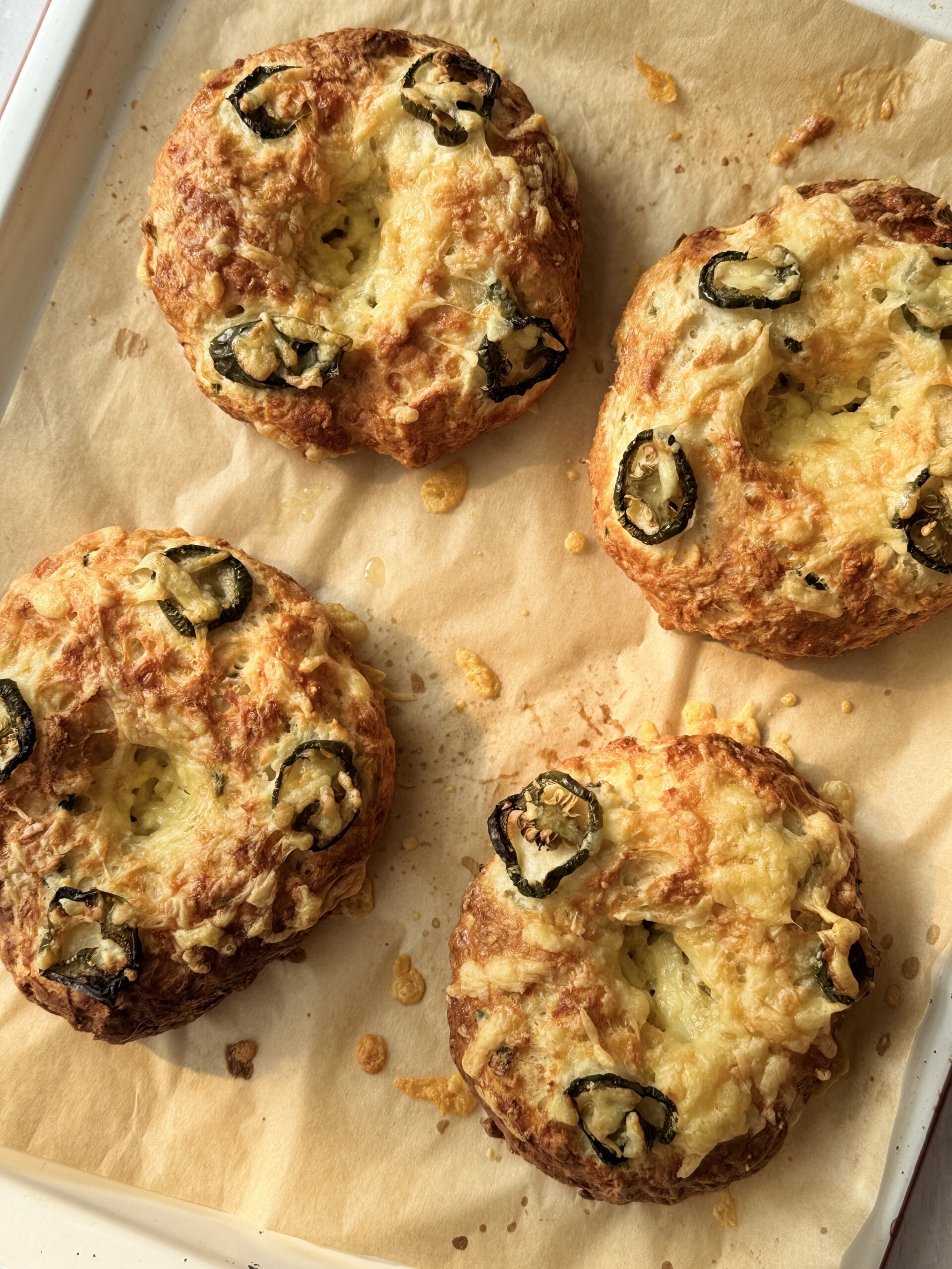 3 ingredient bagel with cheese and jalapeno on a tray.