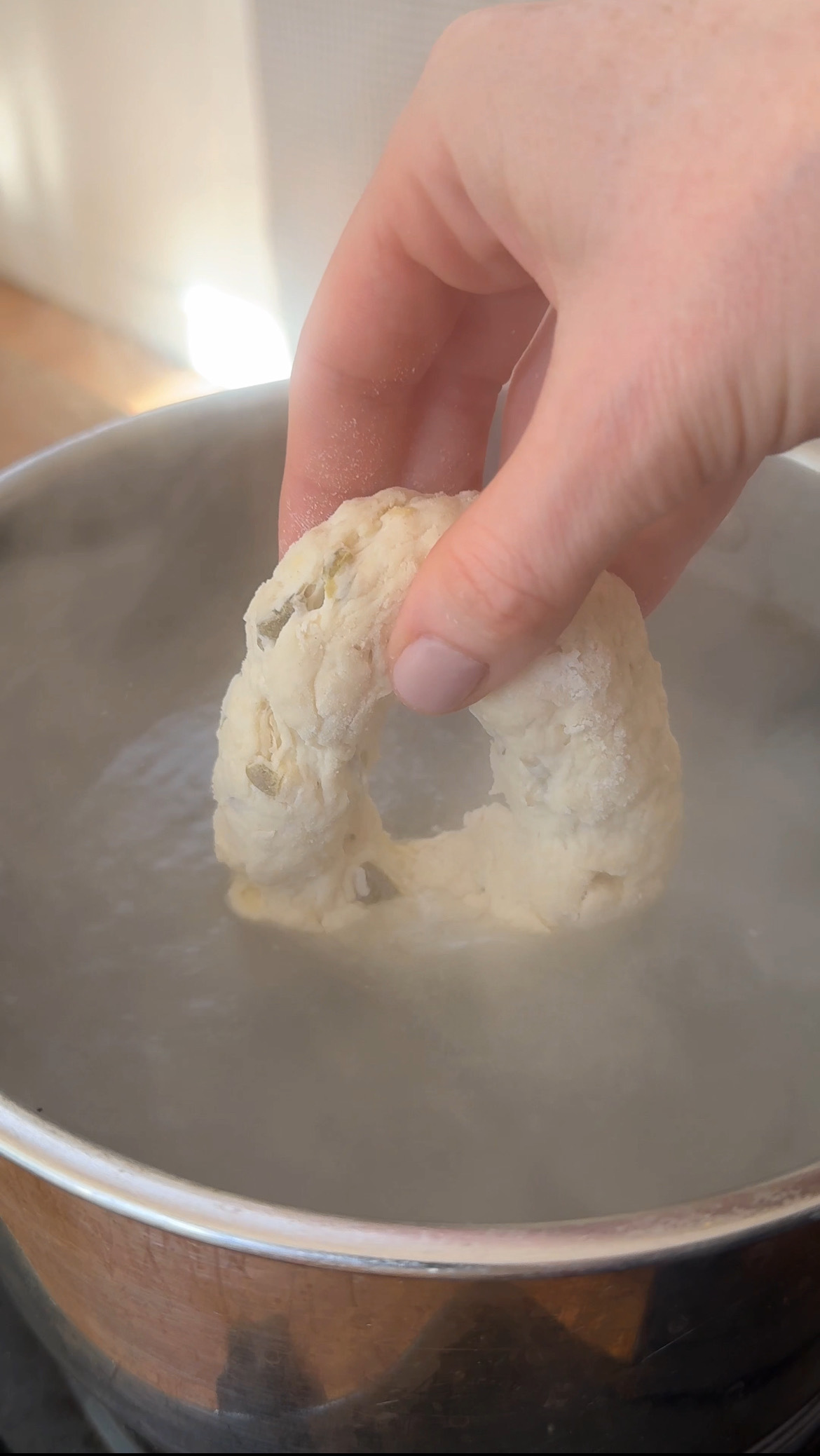 adding formed bagels to boiling water.