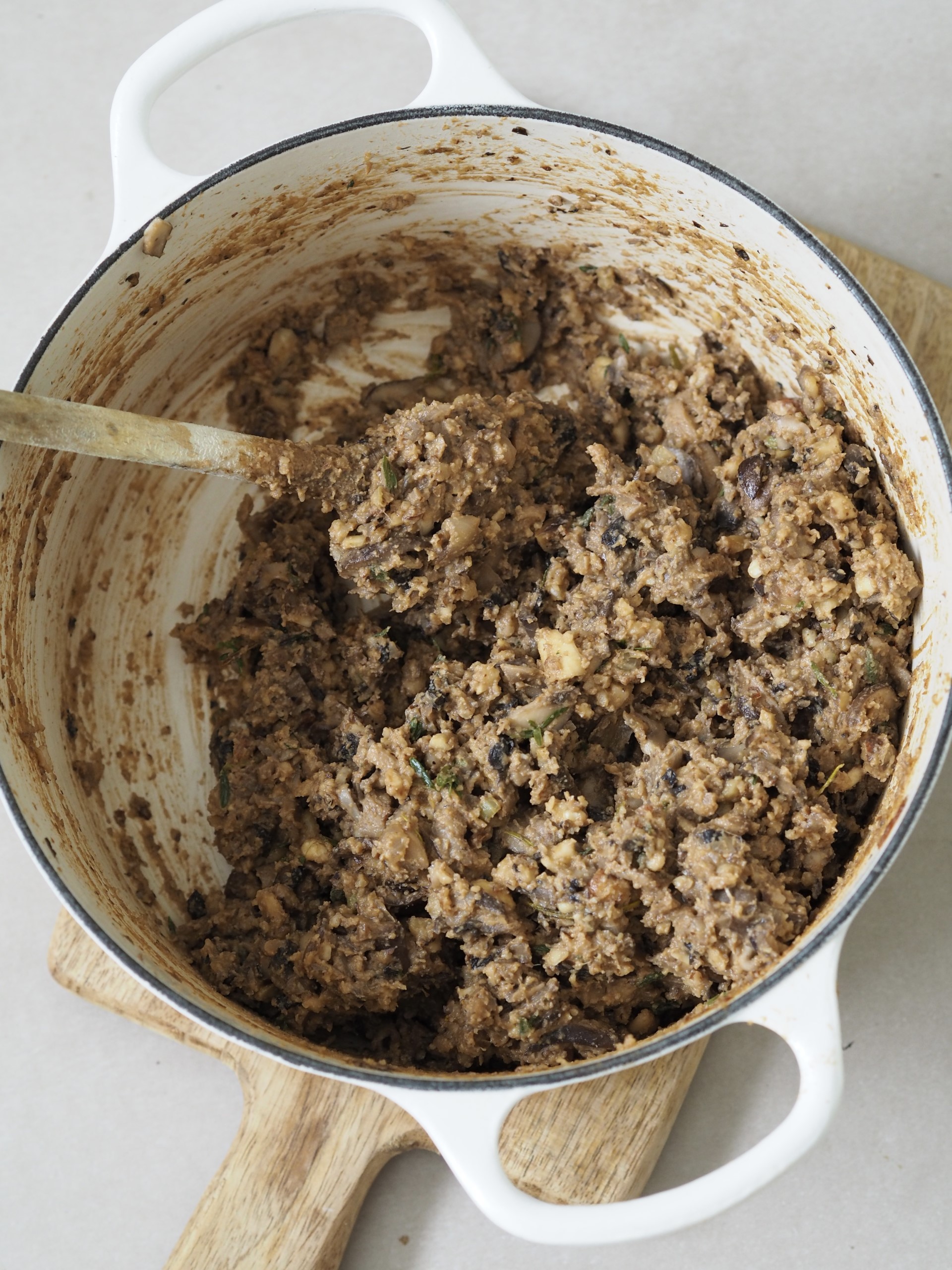 Adding ingredients to a pot for Nut Roast Wellington