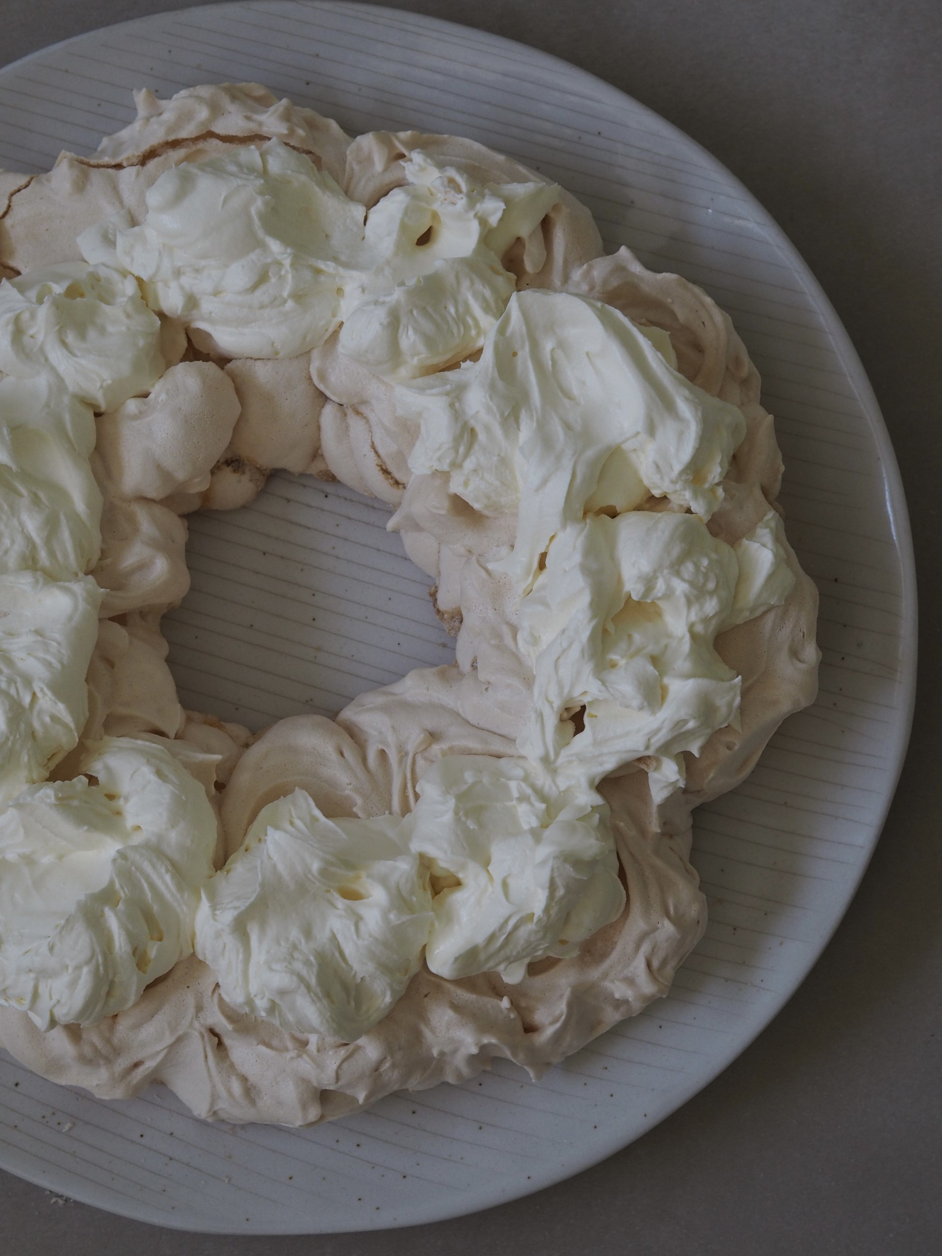 Adding whipped cream to the pavlova