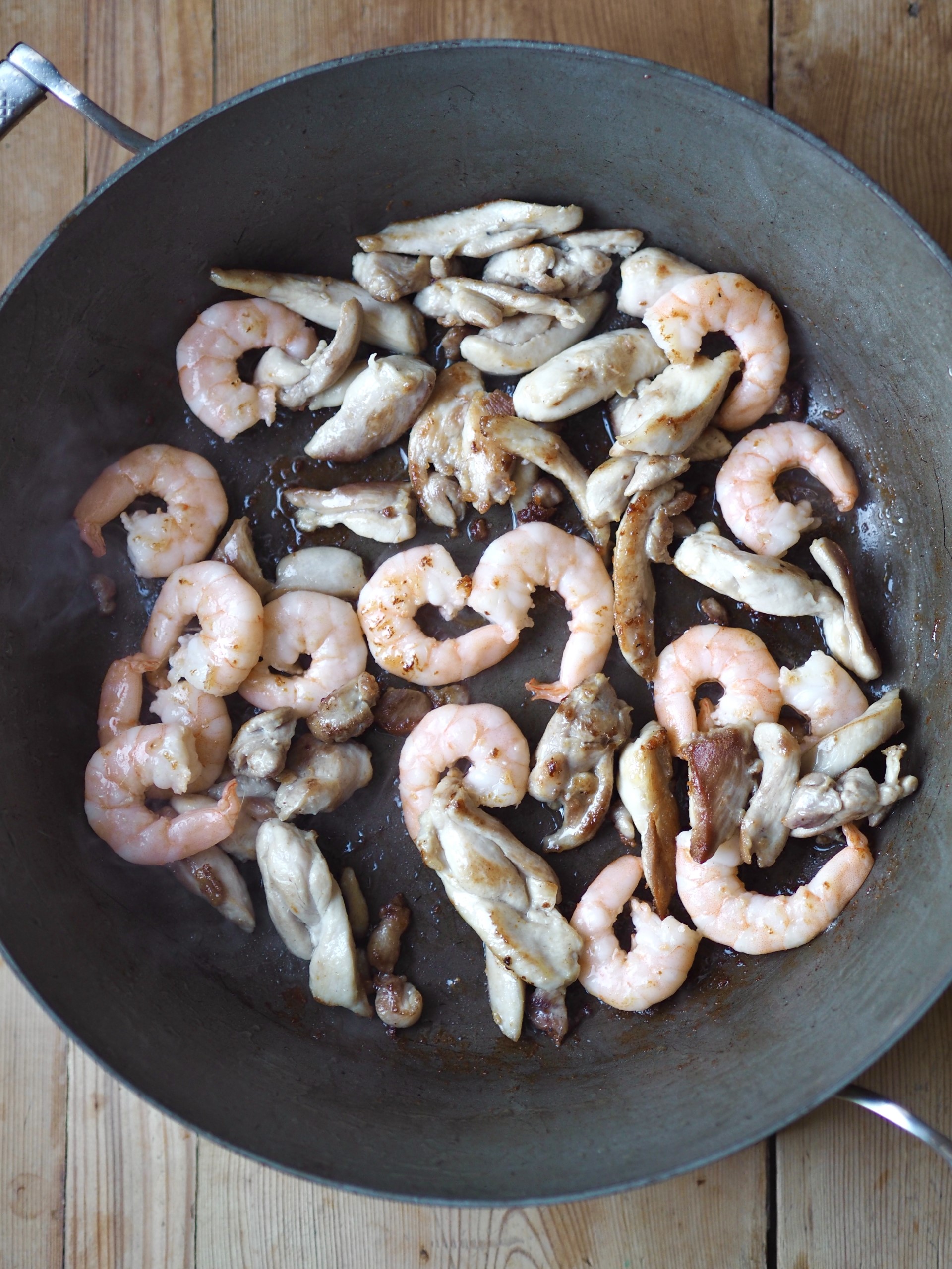 Frying prawns and chicken strips in a pan