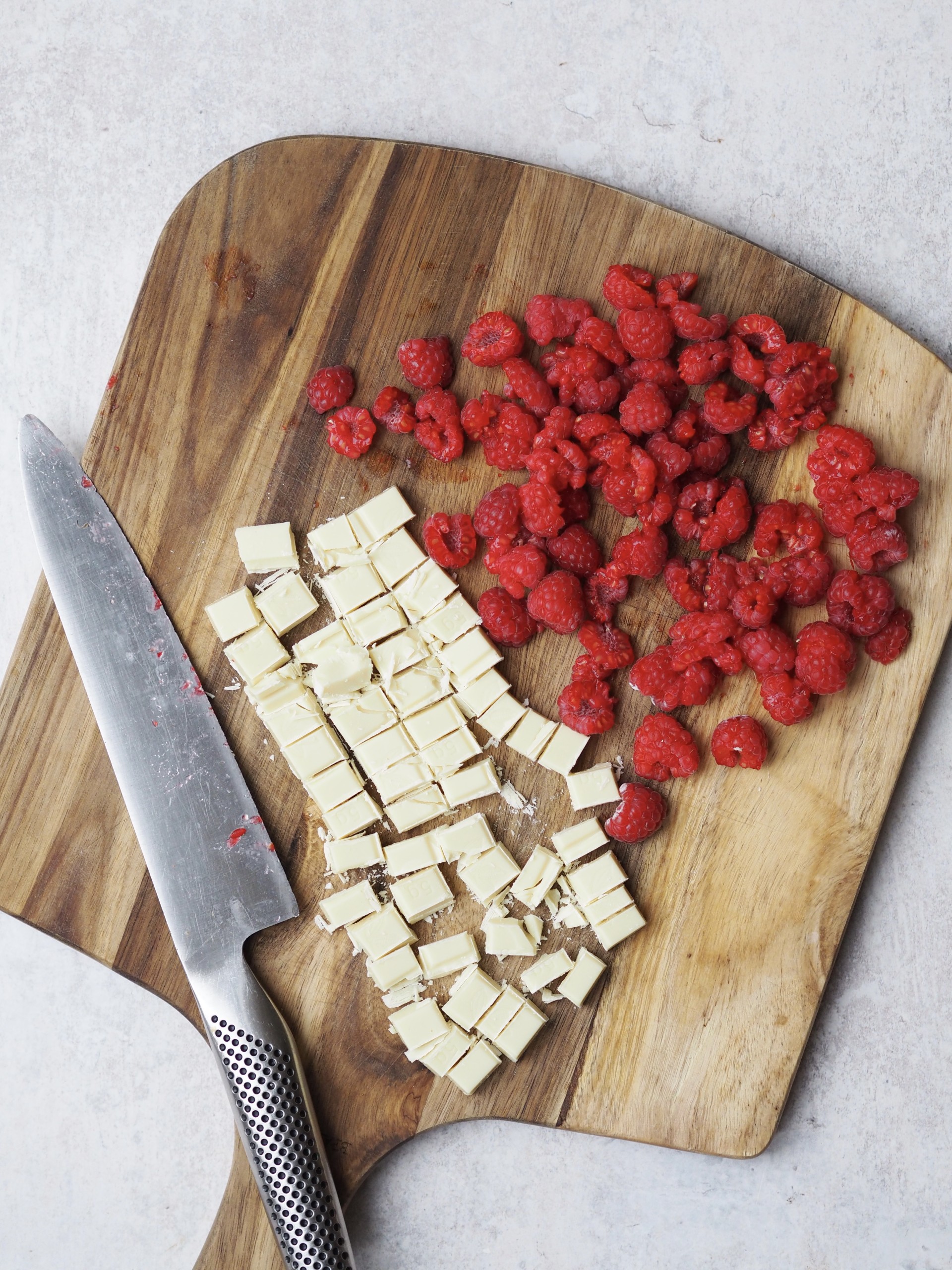 Raspberries and chopped chocolate on a chopping board