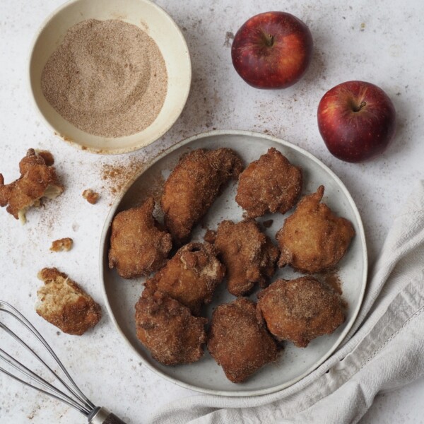 Apple Sauce Fritters on a plate with a bowl of cinnamon sugar