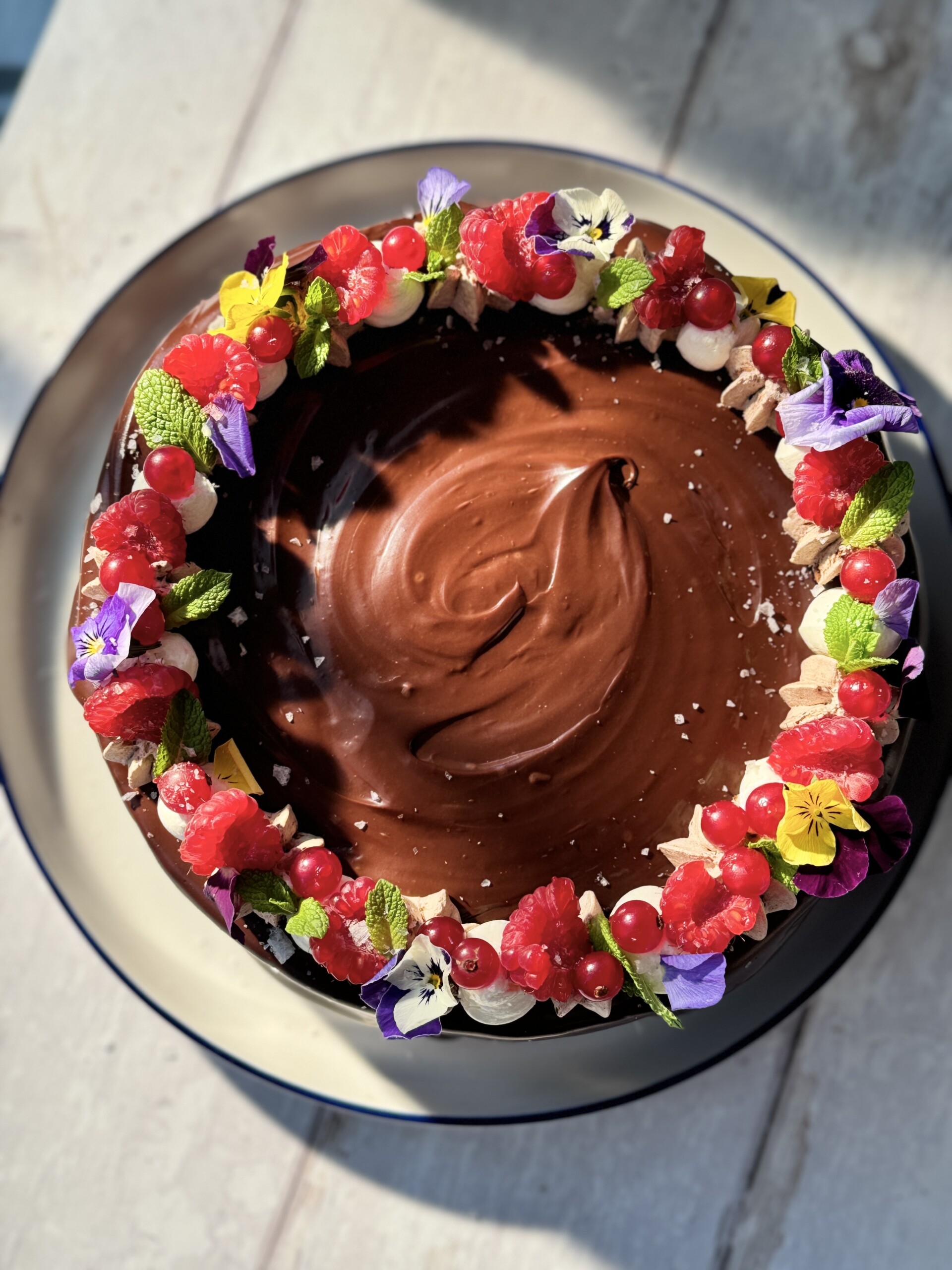 chocolate cake with chocolate mousse, edible flowers and fruit