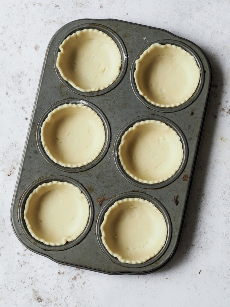 Muffin tin lined with shortcrust pastry. 