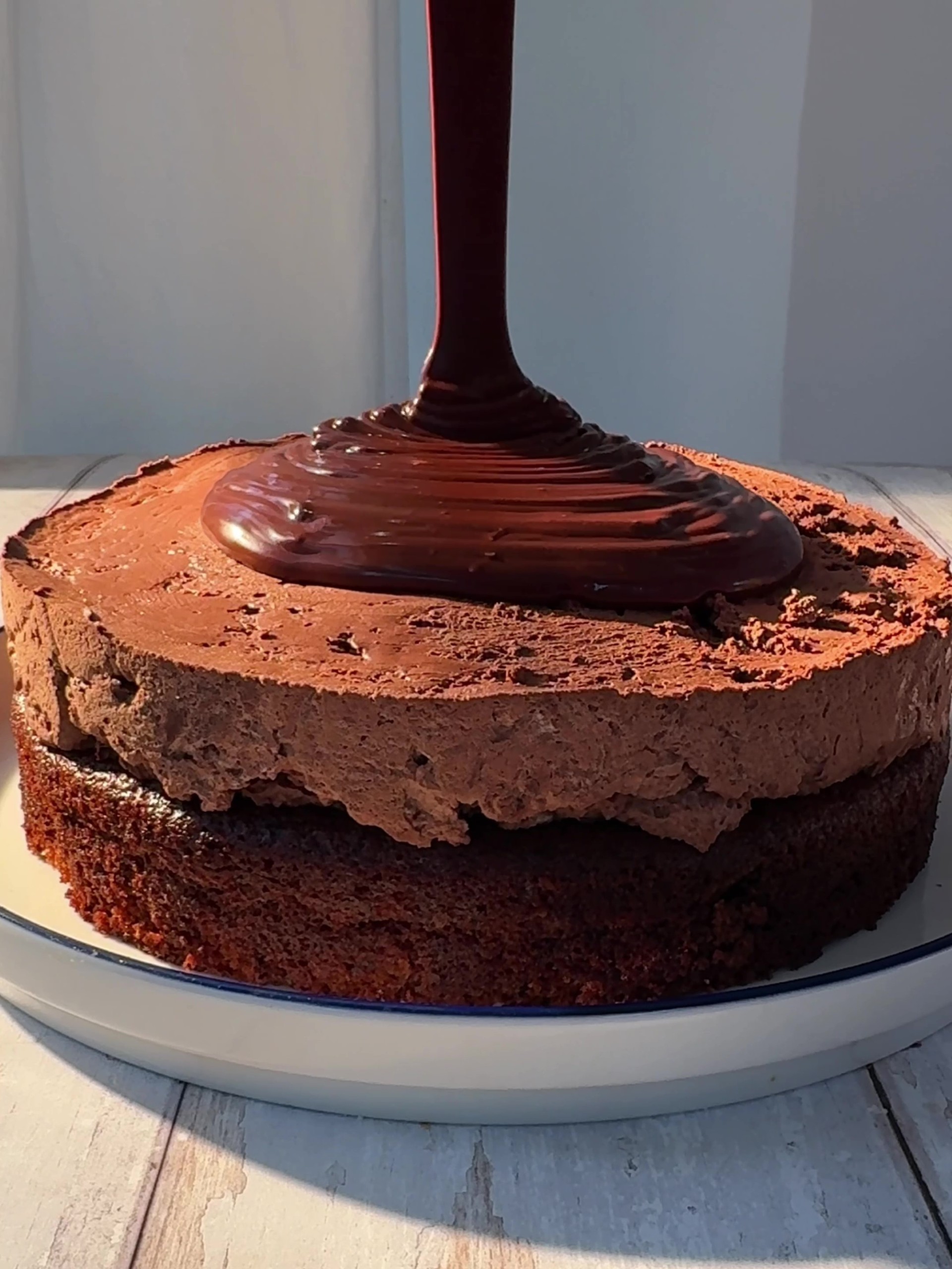 Pouring the ganache over the chocolate cake