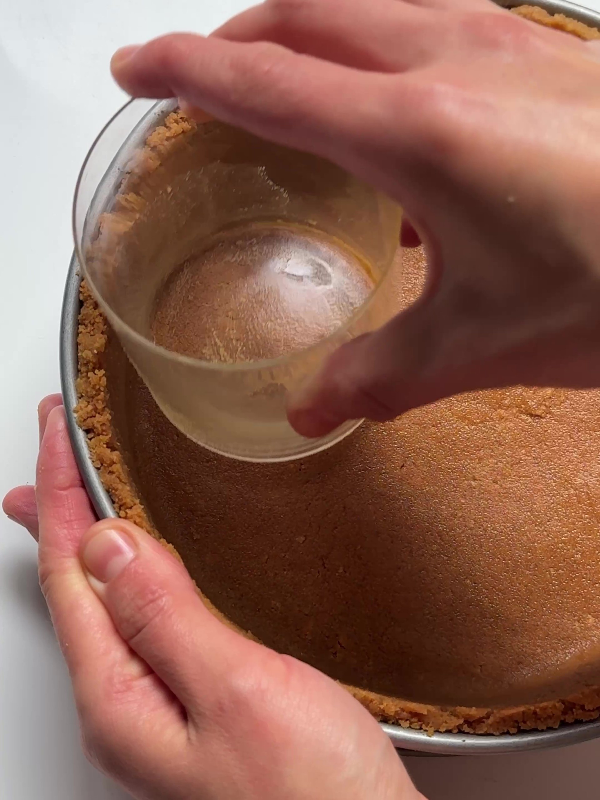 Compressing biscuit mixture in baking tin.