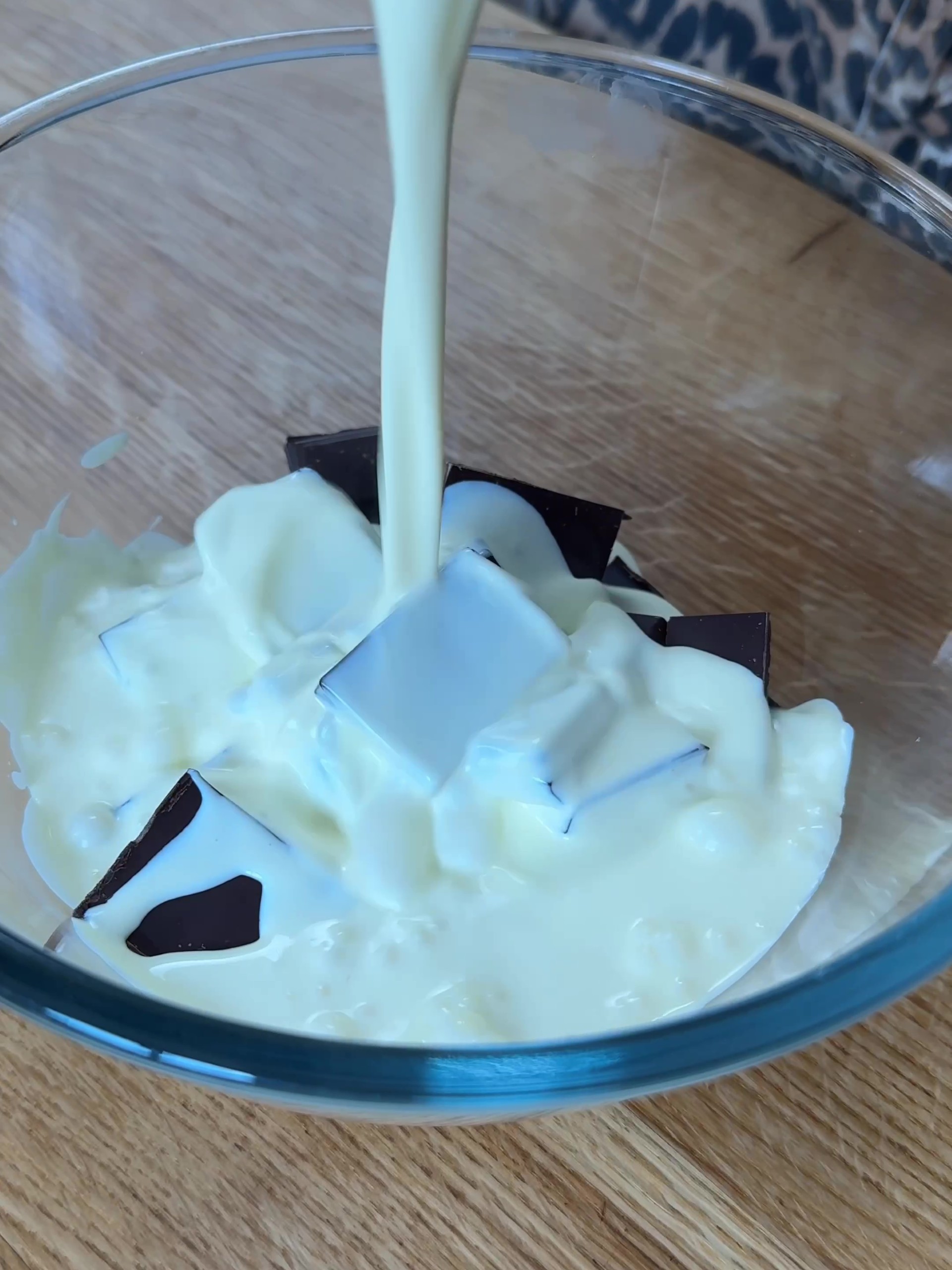 Pouring cream over chopped chocolate 