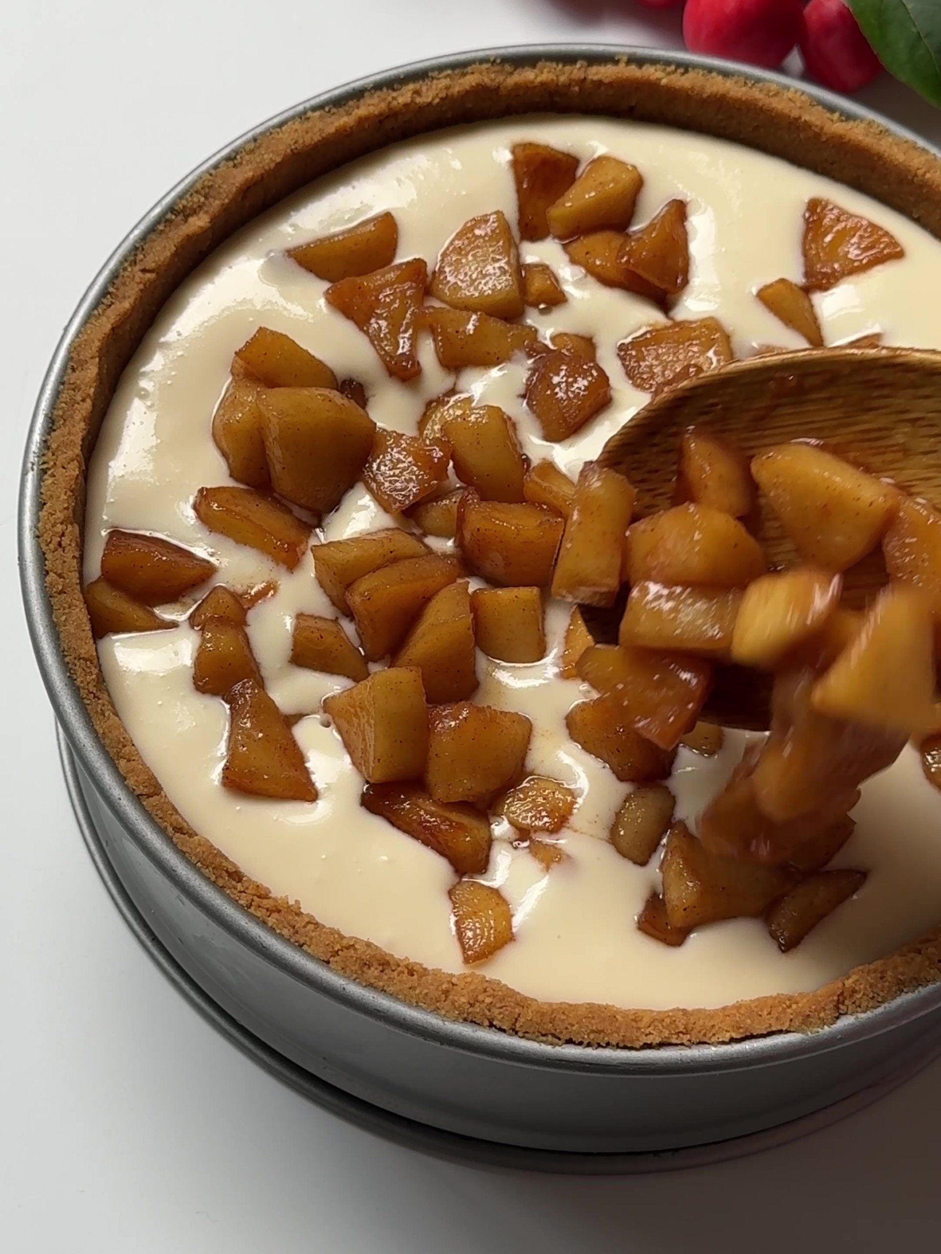 Adding apples on top of cheesecake filling