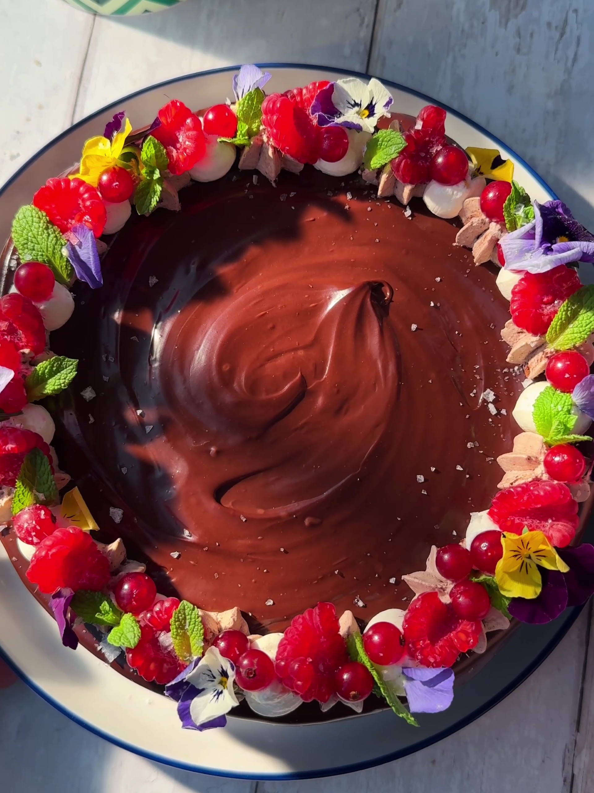 A decorated chocolate mouse cake with edible flowers