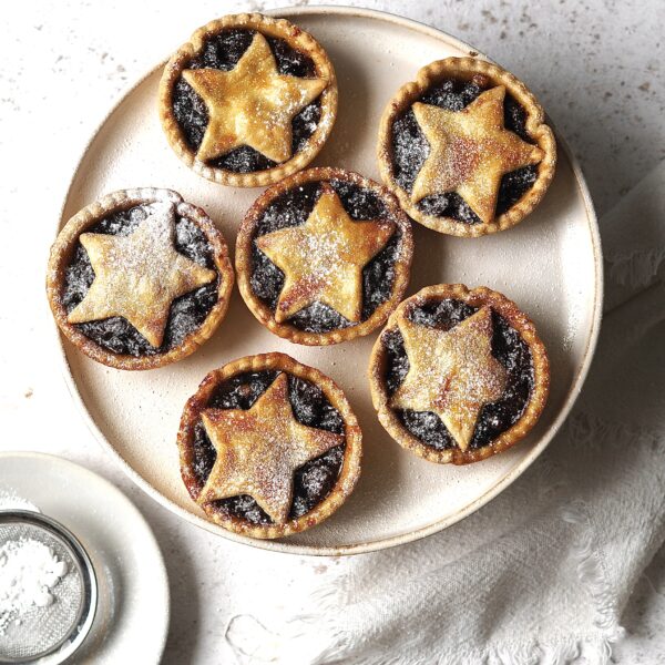 Plate of mince pies dusted with icing sugar.