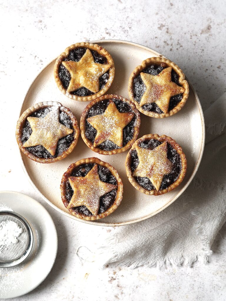 Plate of mince pies dusted with icing sugar. 