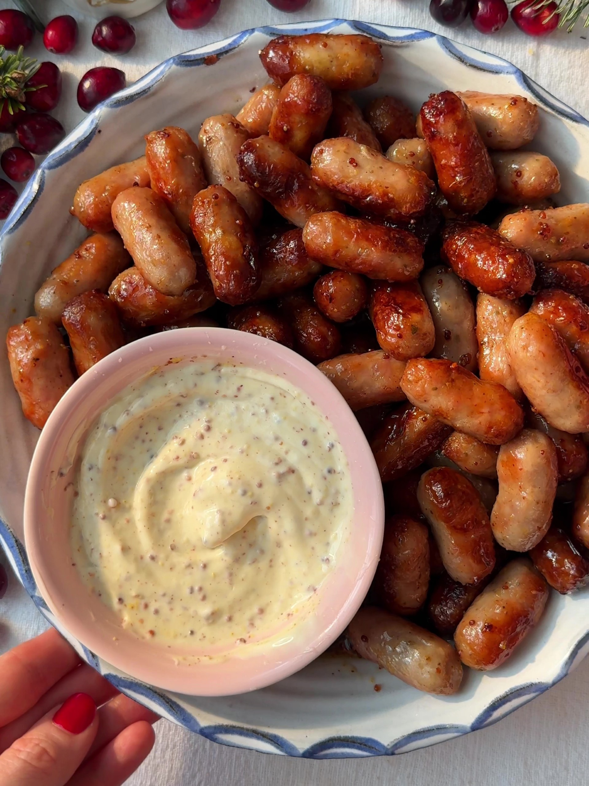 Honey Mustard Sausages in a serving dish with a bowl of dipping sauce.