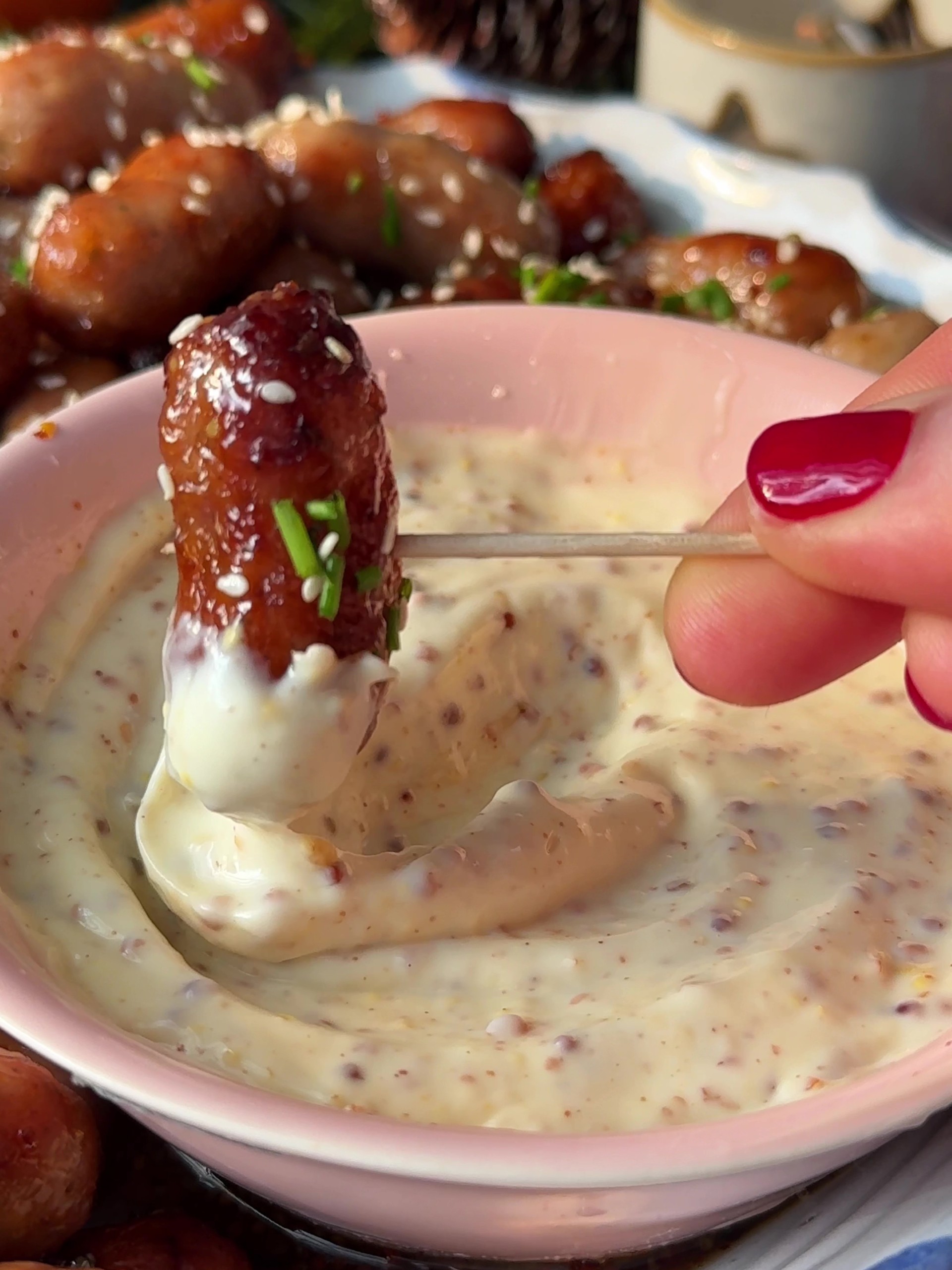 Dipping a sausage in mayo and mustard dip.