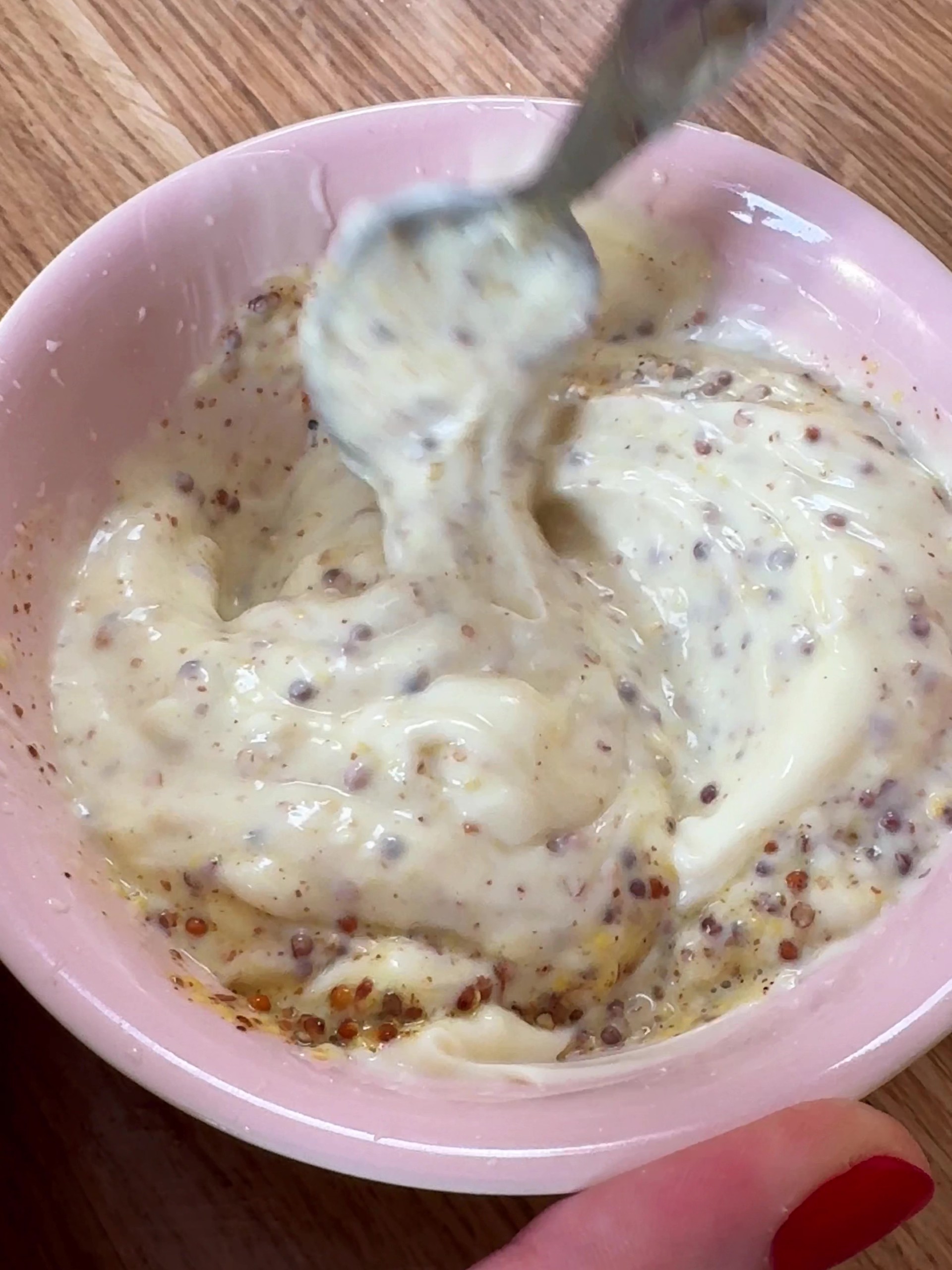 Mixing mustard and mayo in a mixing bowl.