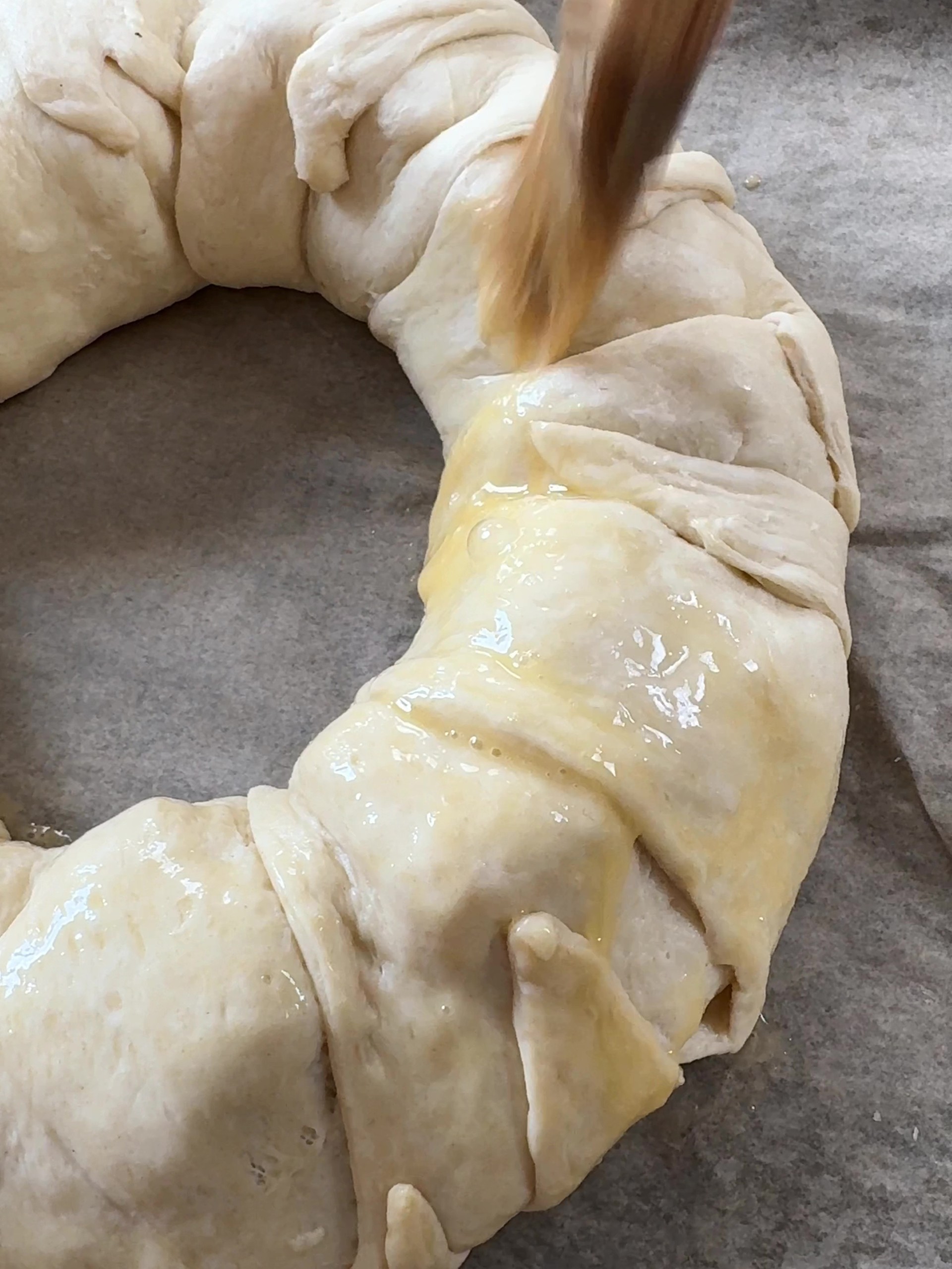 Brushing the Brie Crescent Wreath with egg 