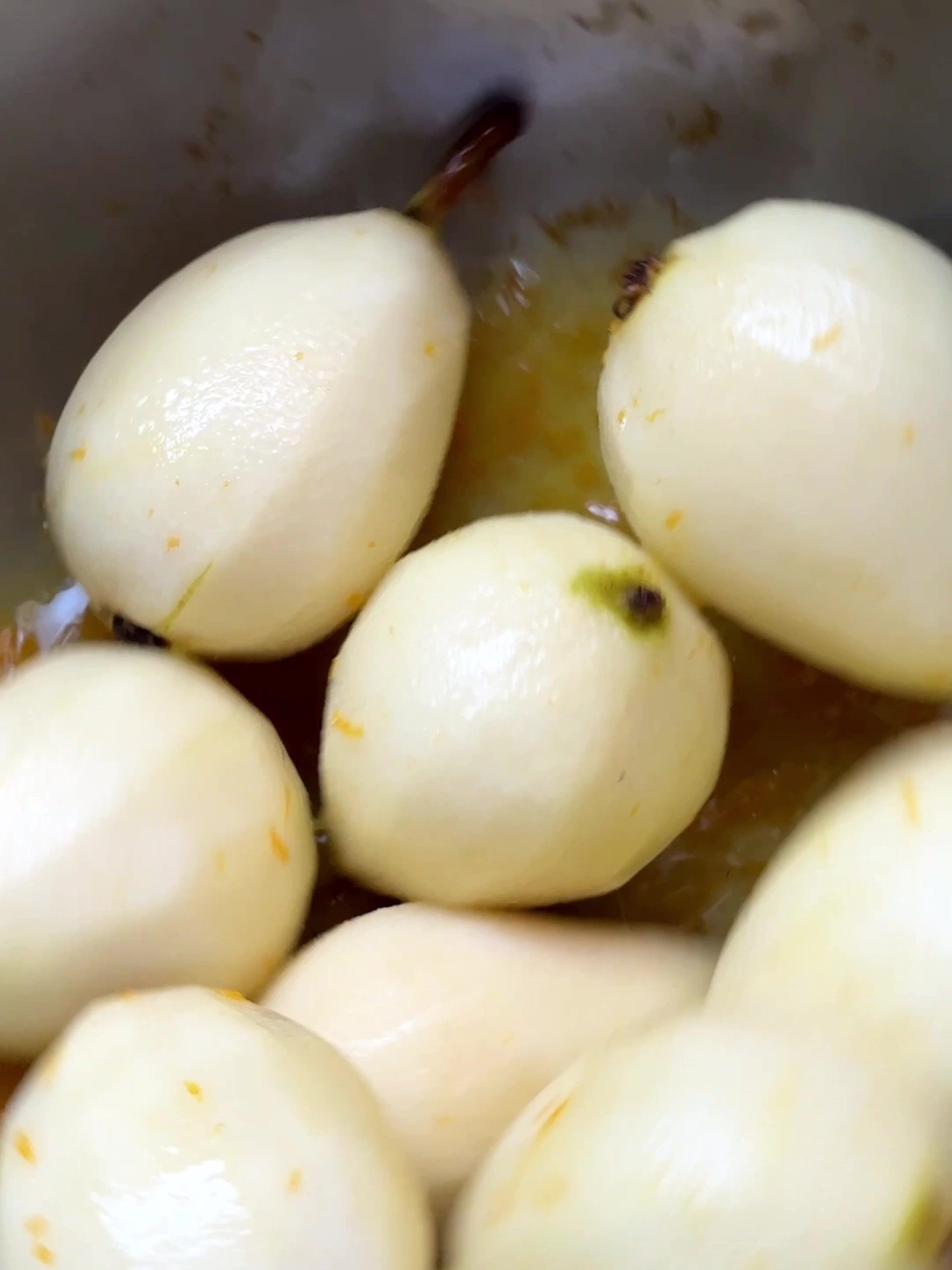 Peeled pears in orange juice